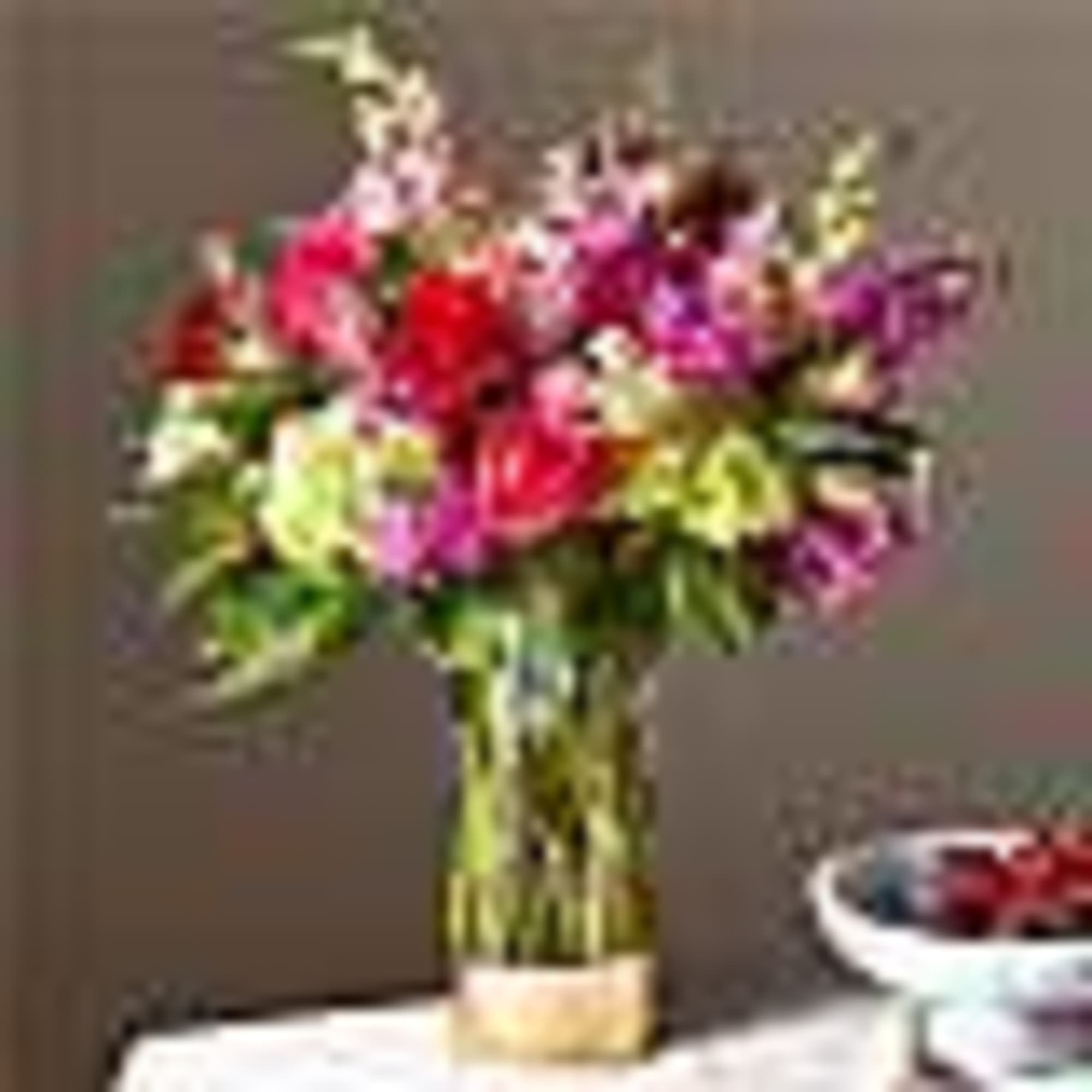 Mixed pink and red flowers in a glass vase