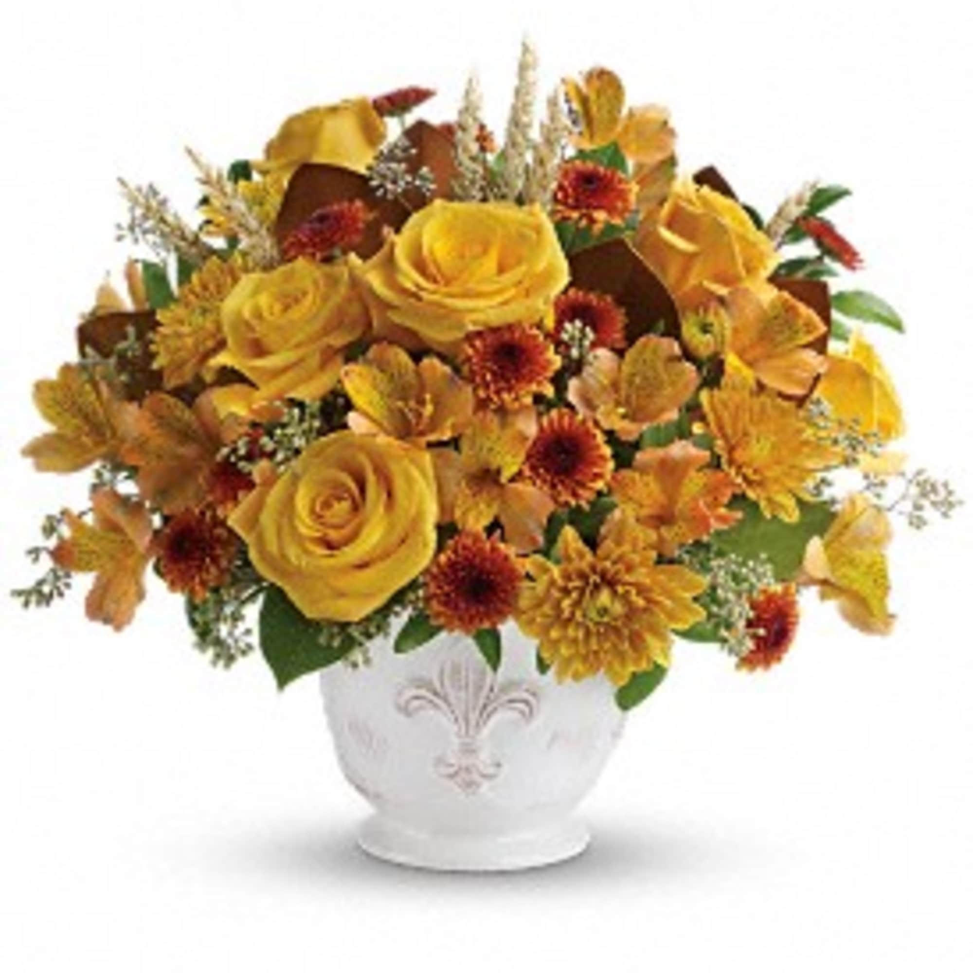 Round arrangement of yellow roses and orange mums in a white ceramic bowl vase