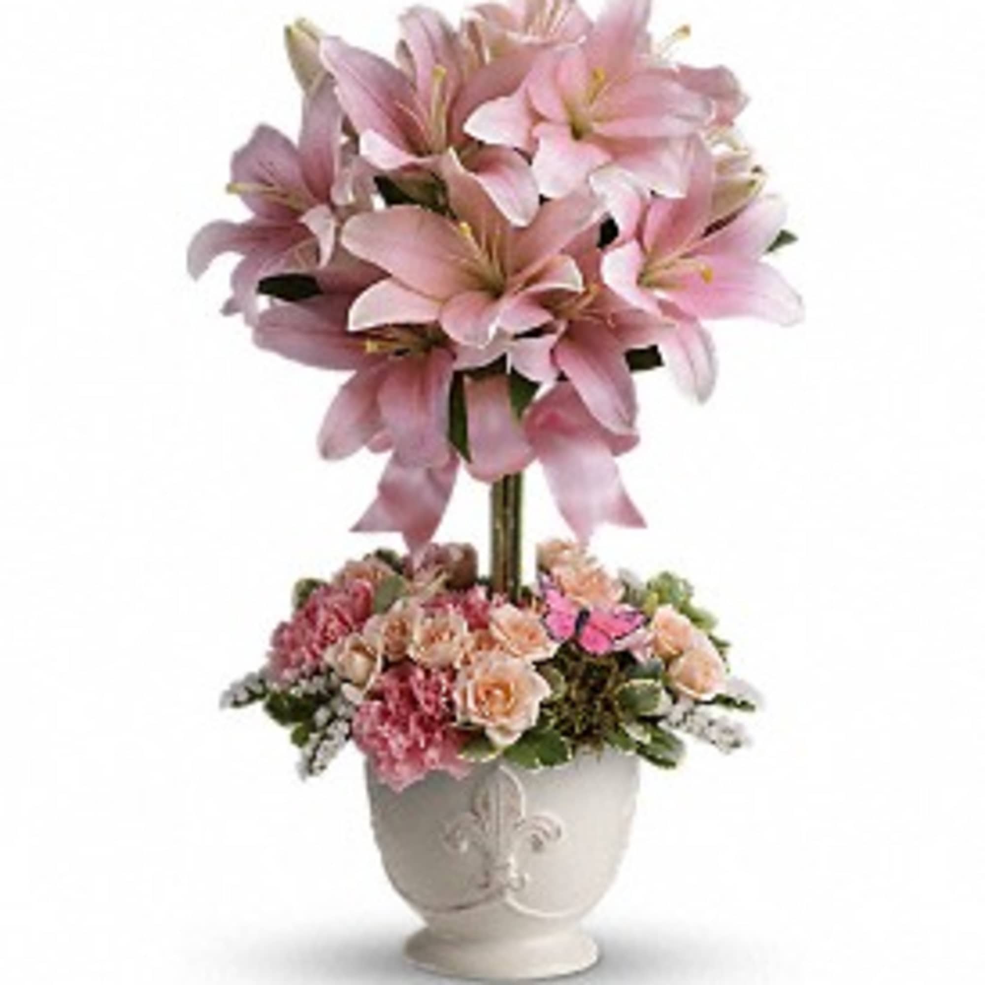 Topiary-style arrangement of pink lilies and mixed pink blooms in a white ceramic urn