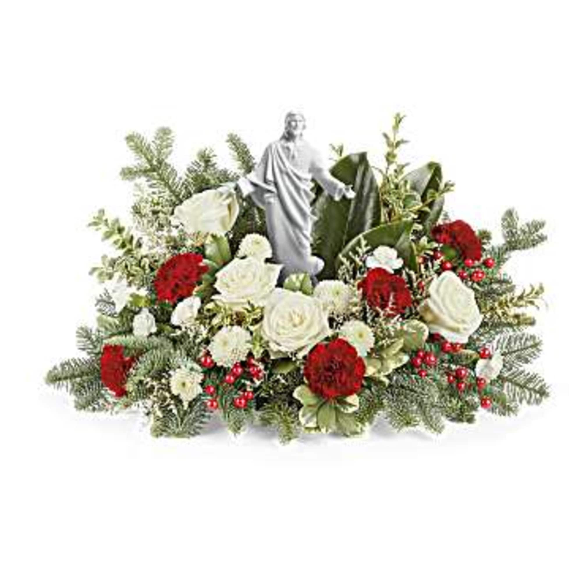 Floral arrangement with a small religious statue in the center