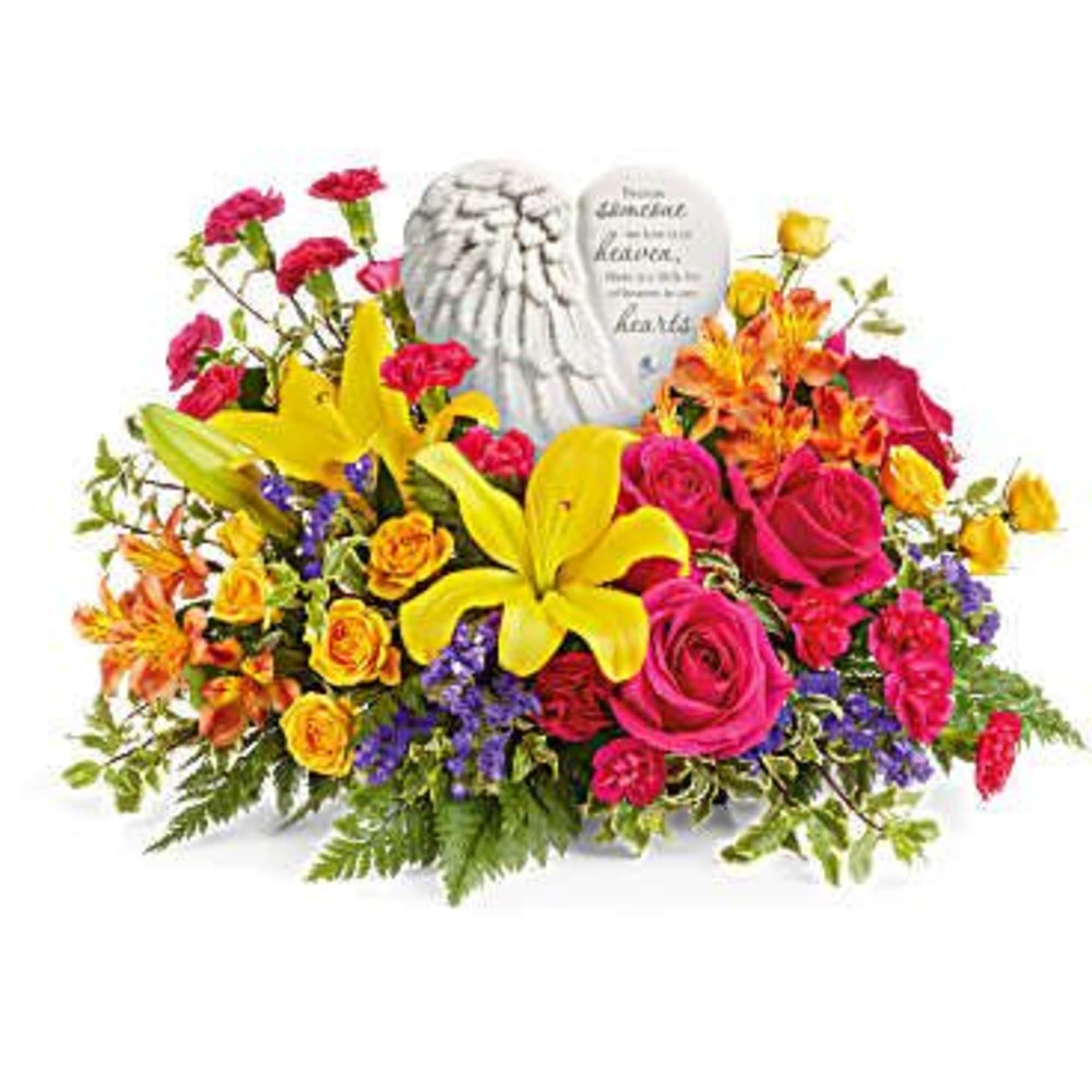 Bright mixed arrangement with yellow lilies, pink roses, orange blooms and a white heart memorial stone