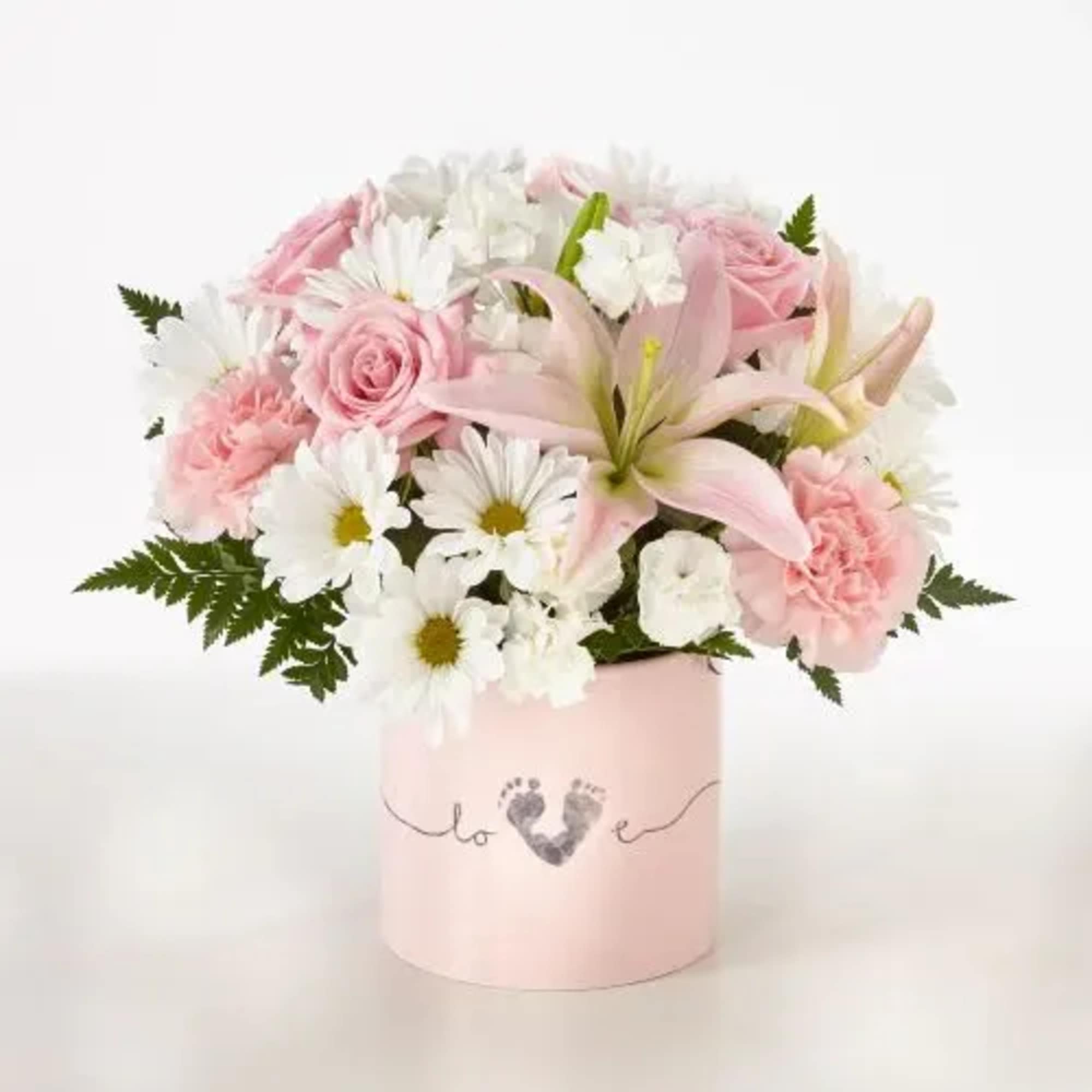 Pink roses and white daisies in a pink hatbox with a baby footprint design.
