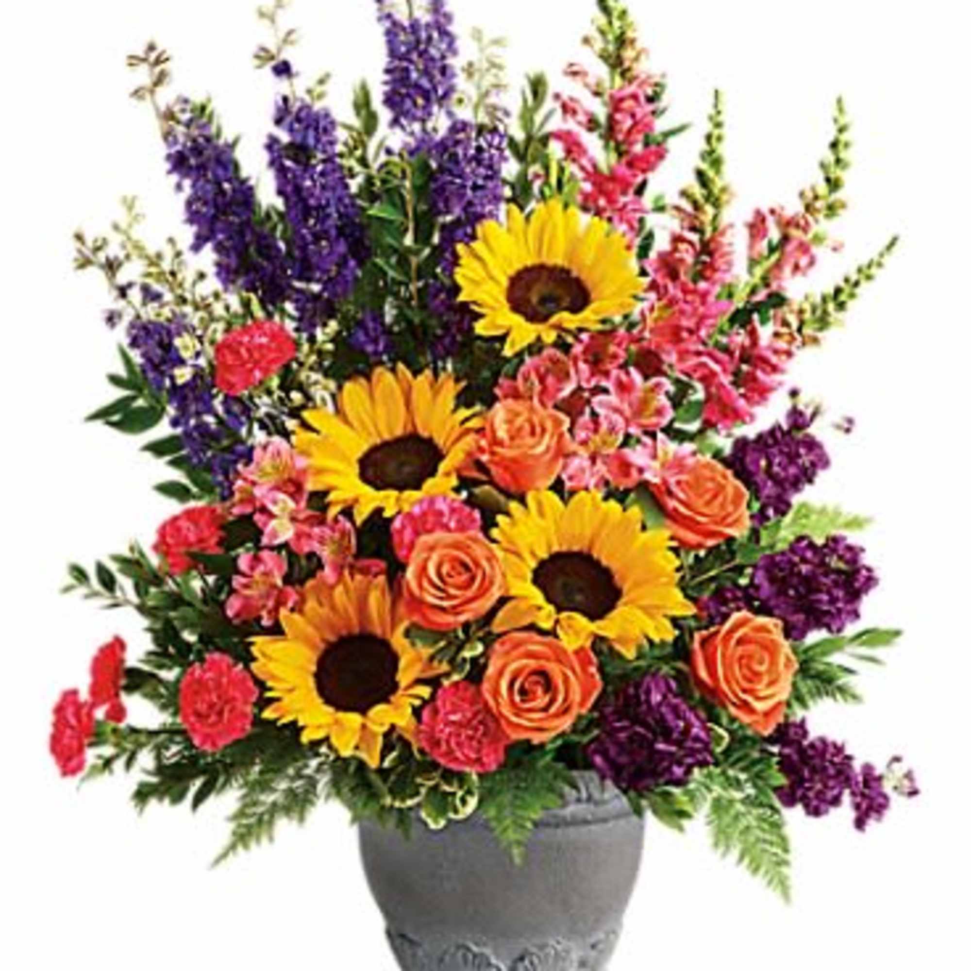 Tall mixed arrangement with sunflowers, orange roses, pink carnations and purple flowers in a gray pot