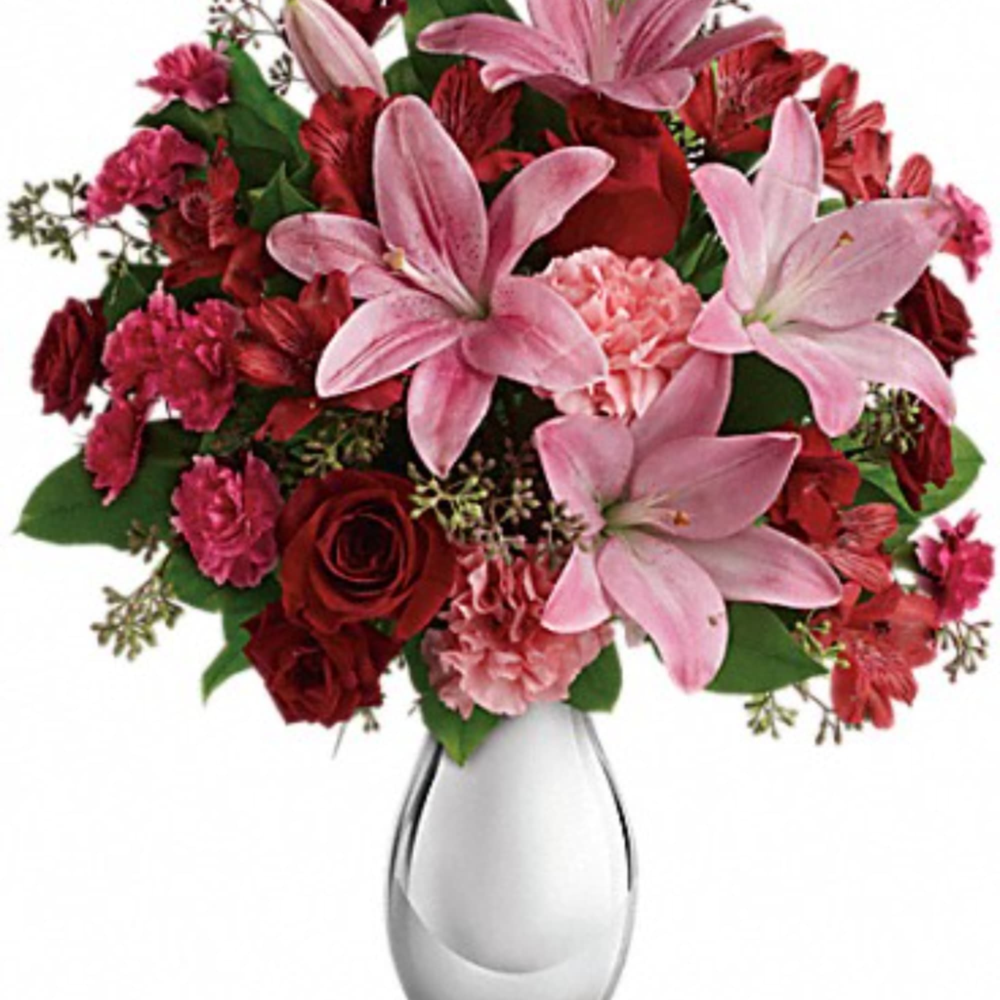 Pink lilies and red roses arranged in a clear glass vase