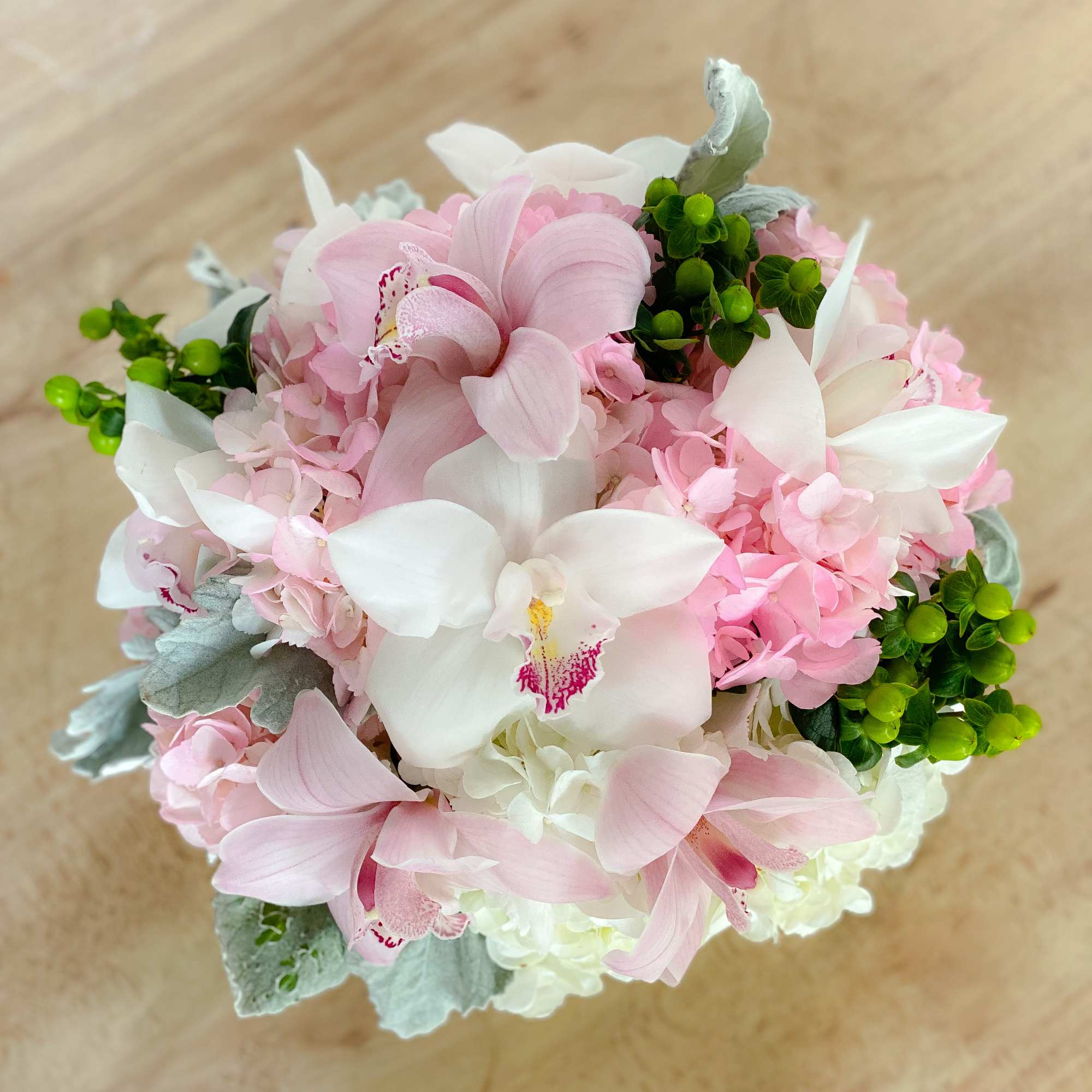 Pink and white orchid bouquet with hydrangea and green berries