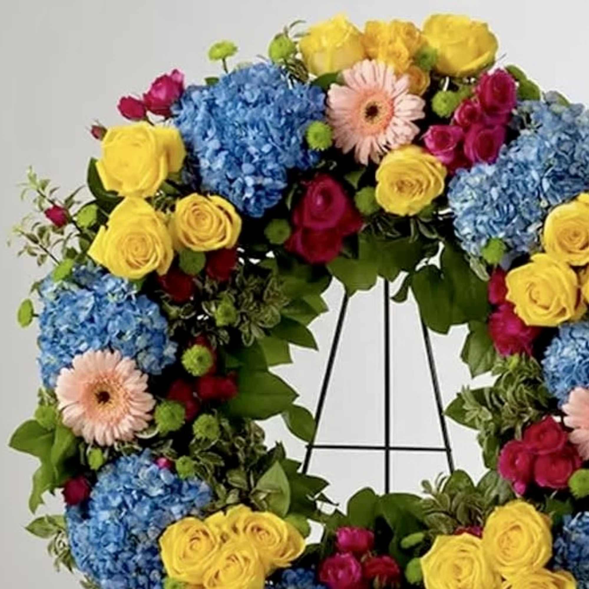 This colorful and bright wreath spray is representative of a life lived, photo 2 of 2