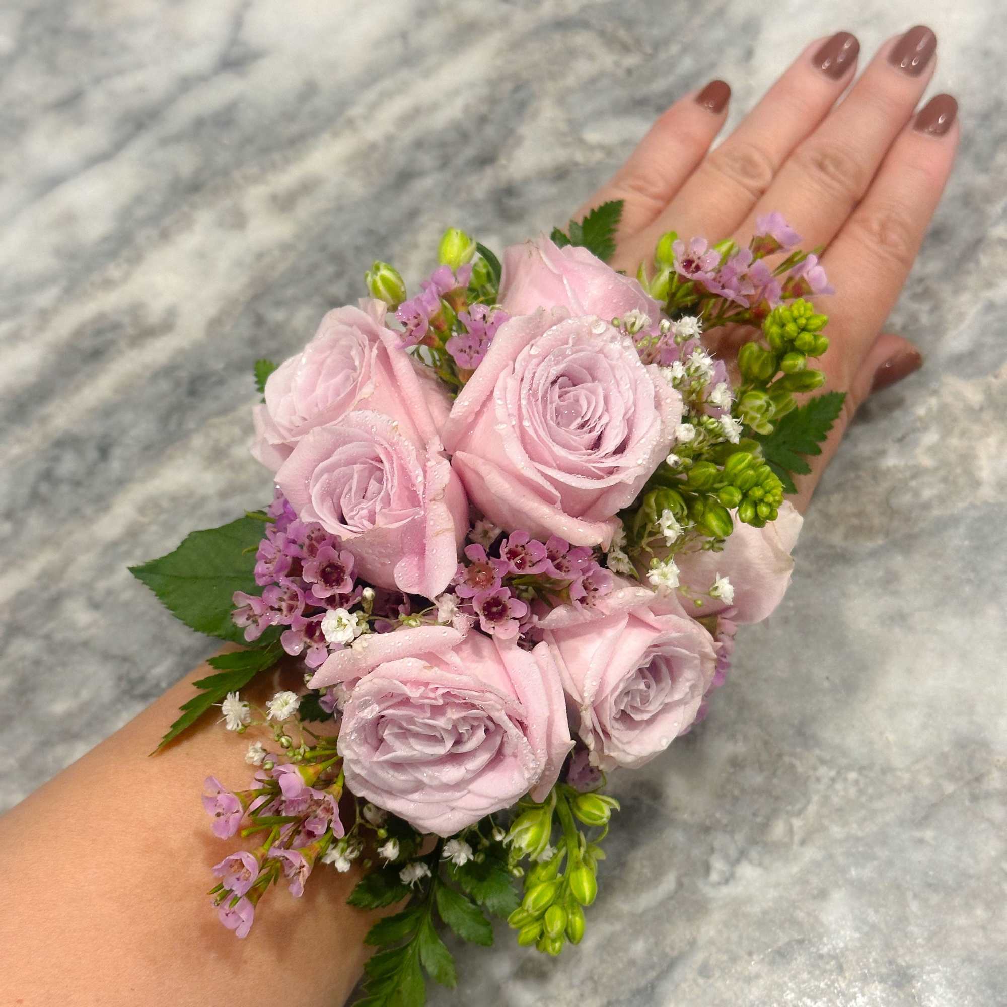 Small pink rose wrist corsage with purple filler flowers