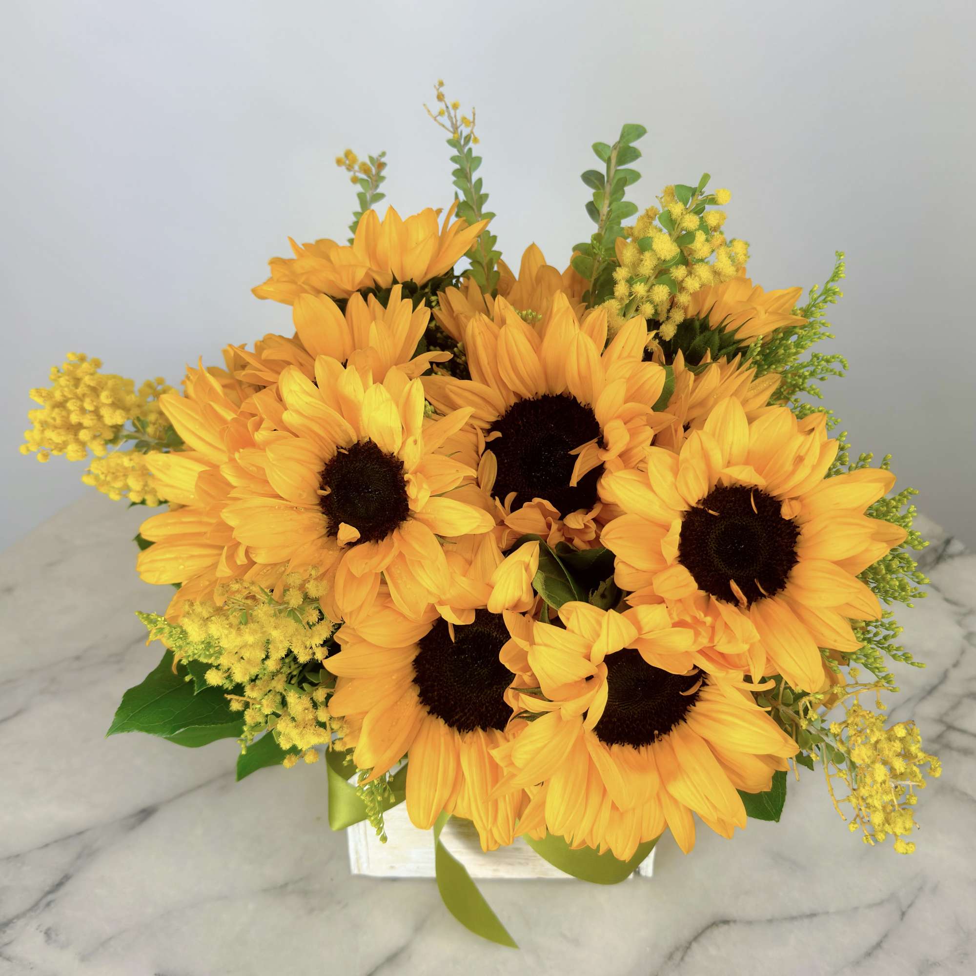 Sunflower arrangement in a white box with yellow filler flowers