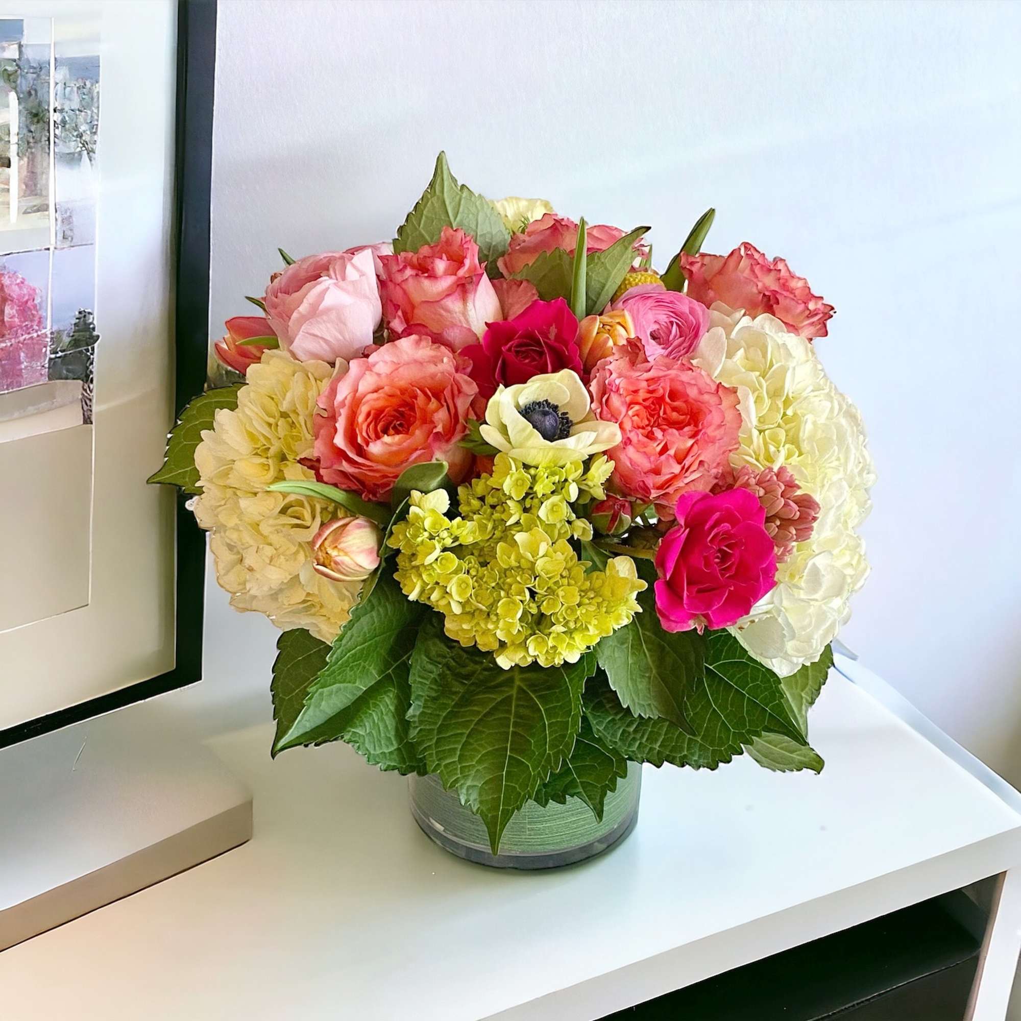 Mixed pink and cream flower arrangement in a glass vase