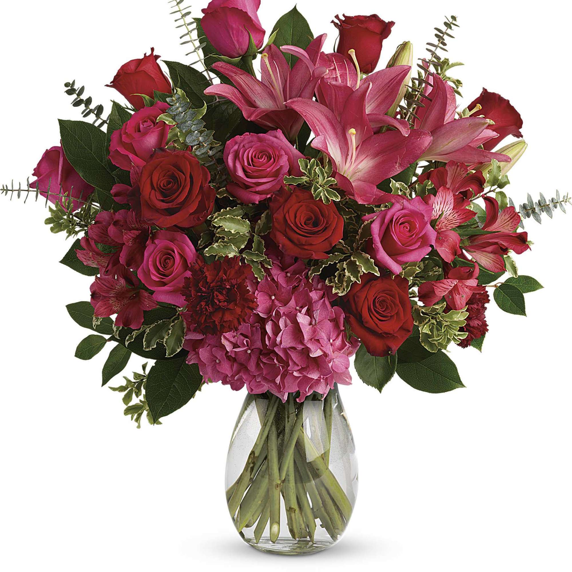 Bouquet of pink lilies, red and pink roses, and hydrangea in a glass vase