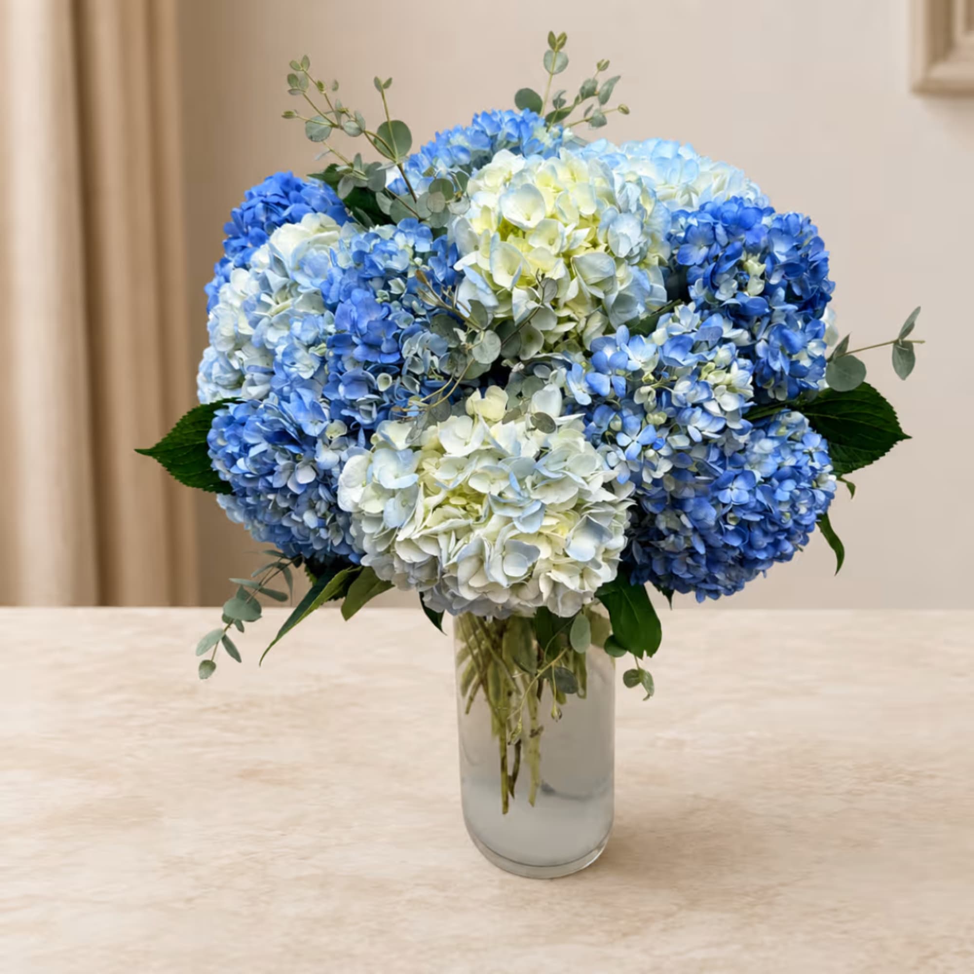 Blue and white hydrangea bouquet in a clear glass vase