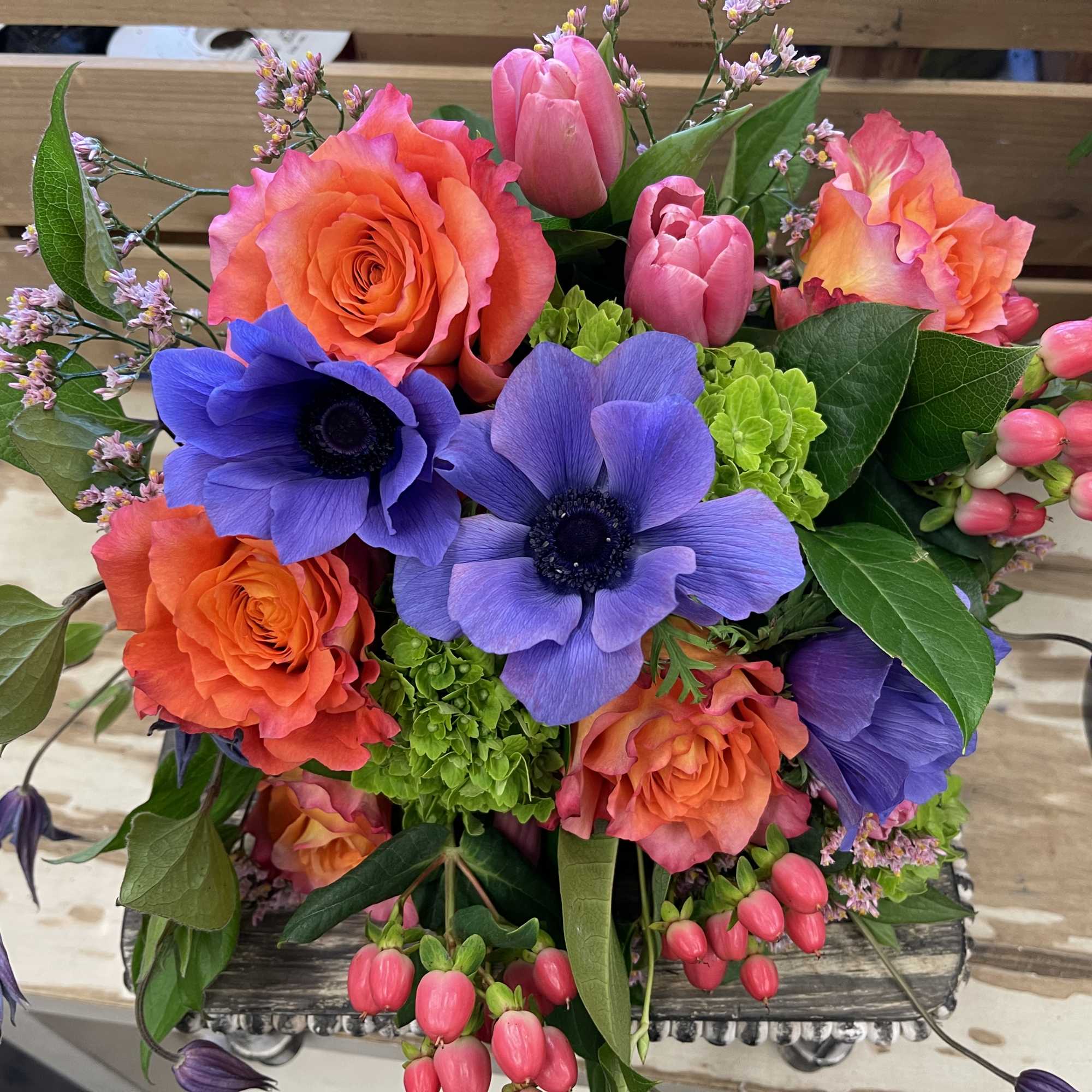 Bouquet of orange roses and purple anemones with pink tulips