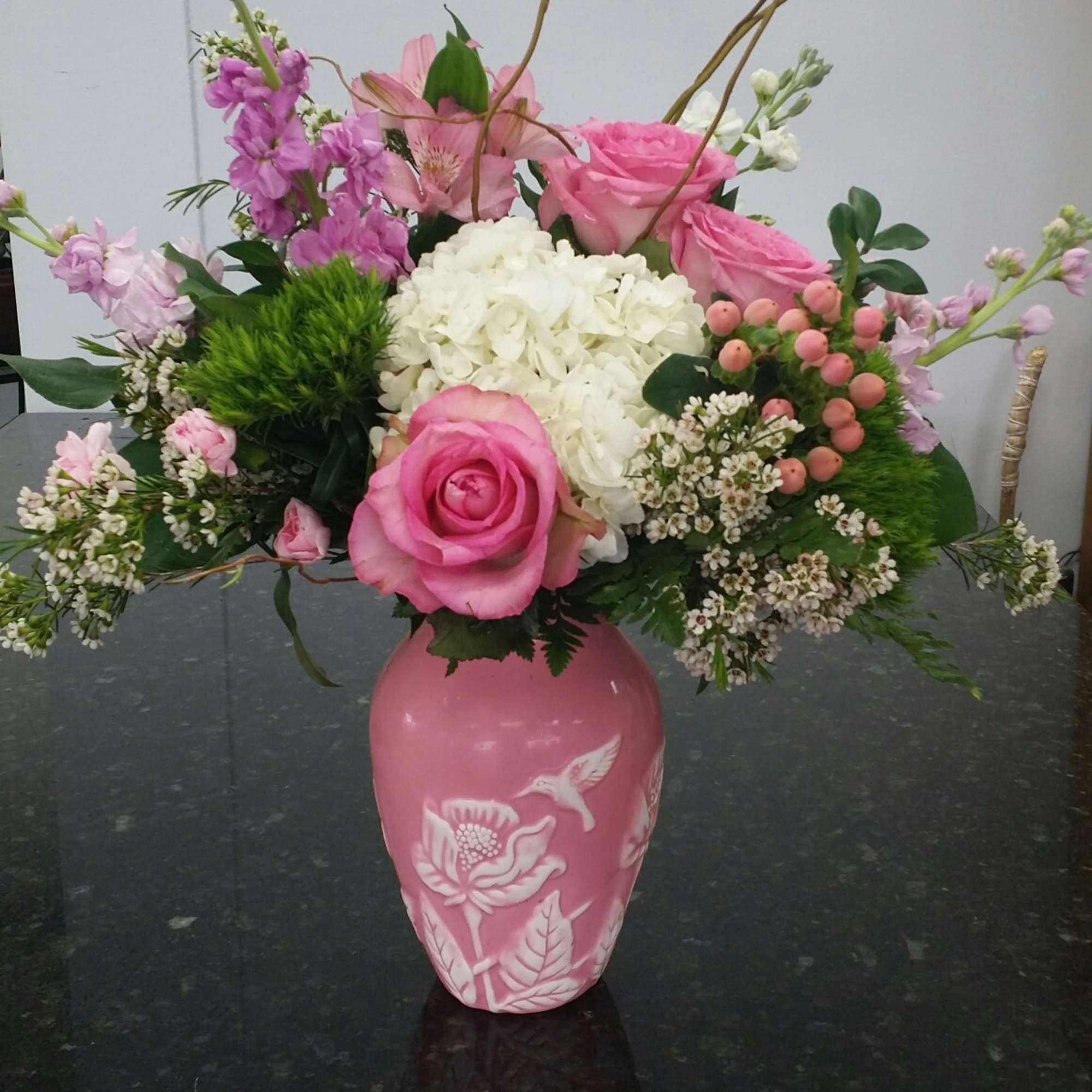 Pink and white mixed flower arrangement in a pink vase