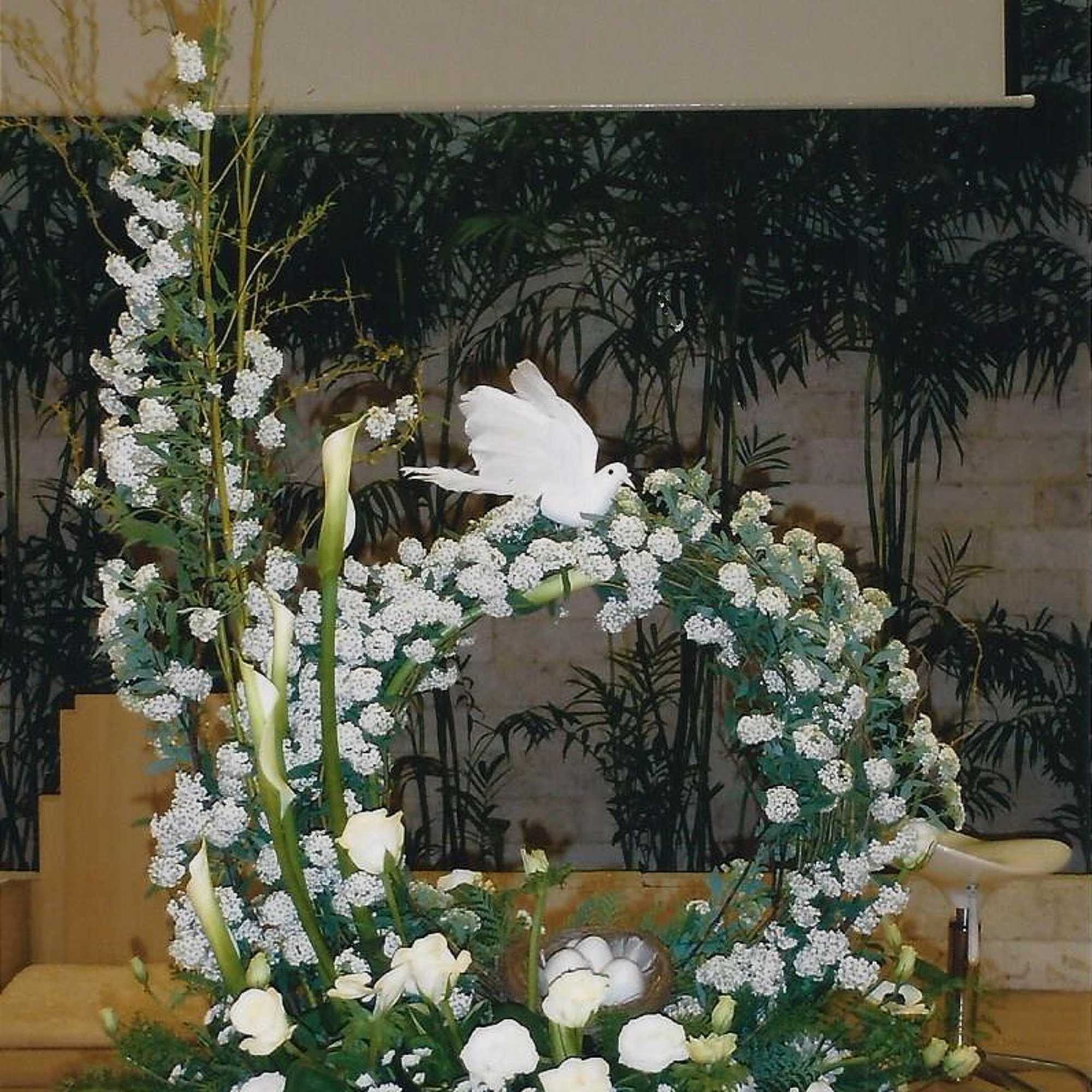 Large white floral arrangement with a dove centerpiece