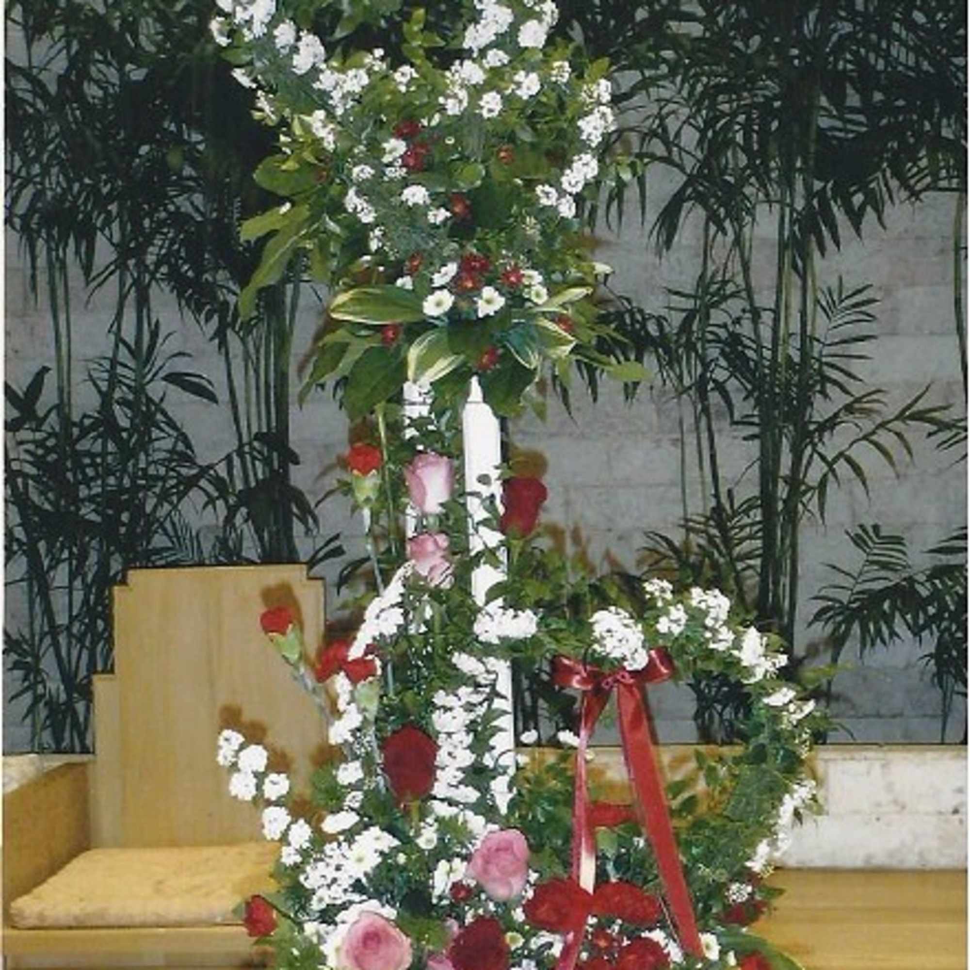 Tall floral arrangement with white and red flowers on a stand