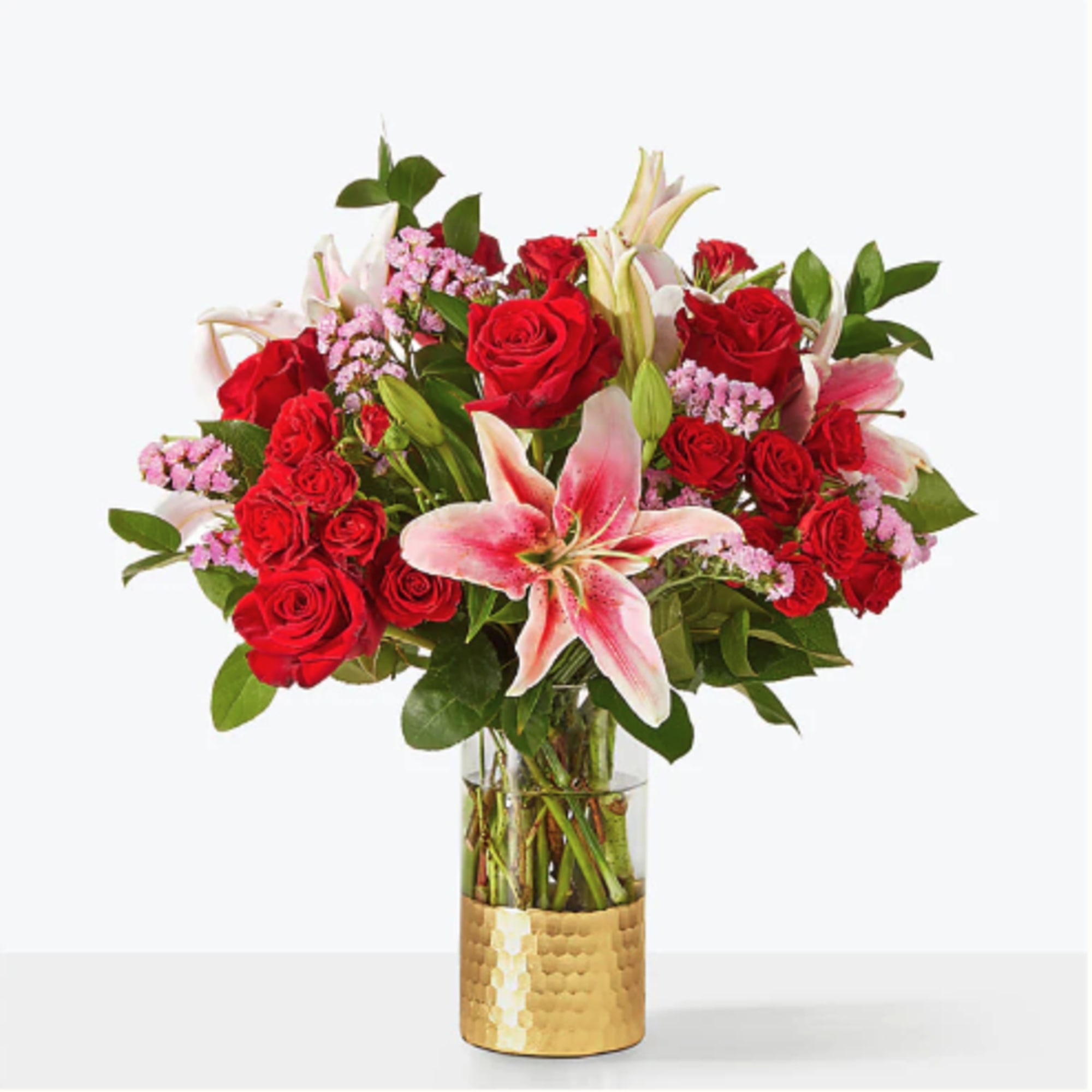Bouquet of red roses and pink lilies in a gold vase