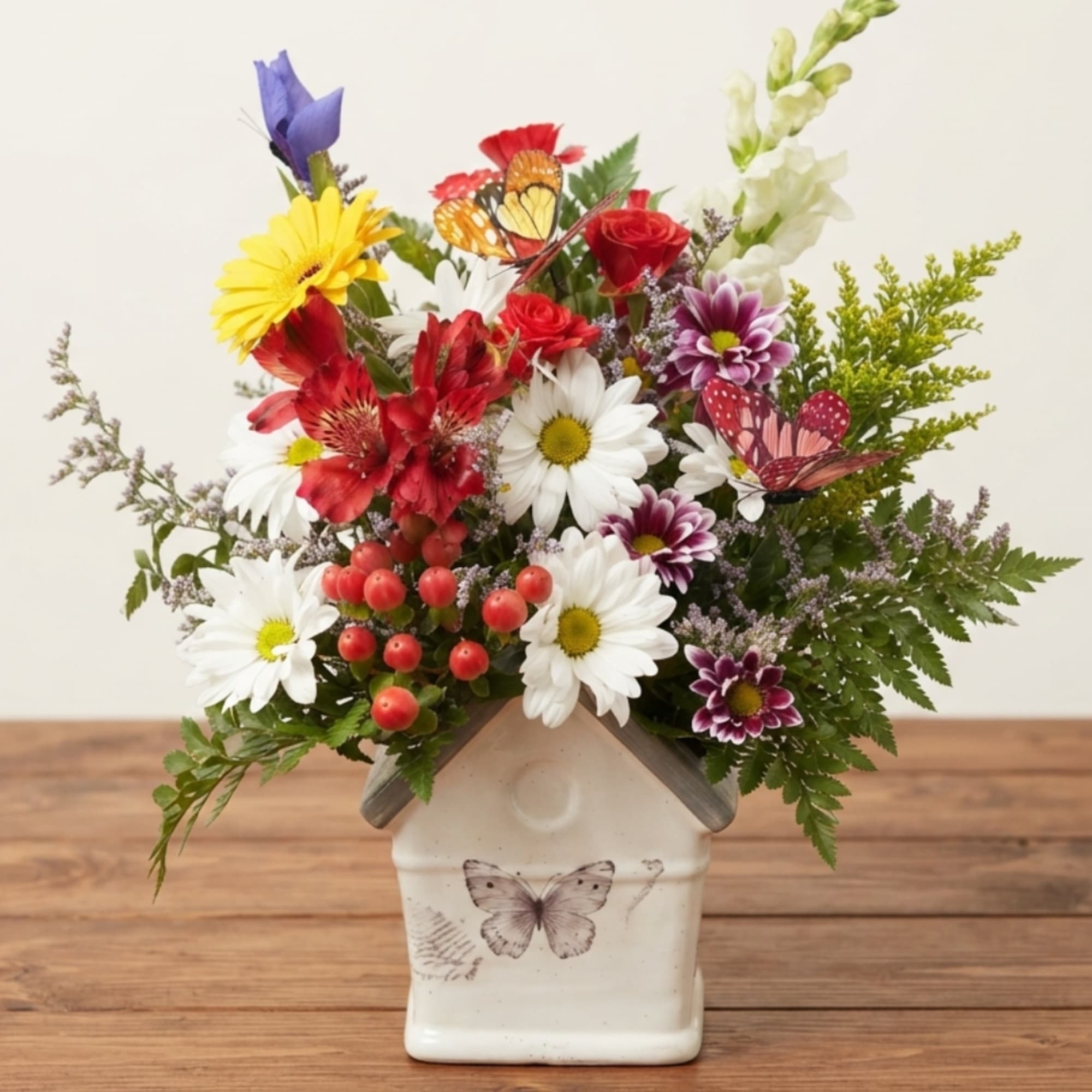 Mixed bouquet in a butterfly-decorated ceramic house vase