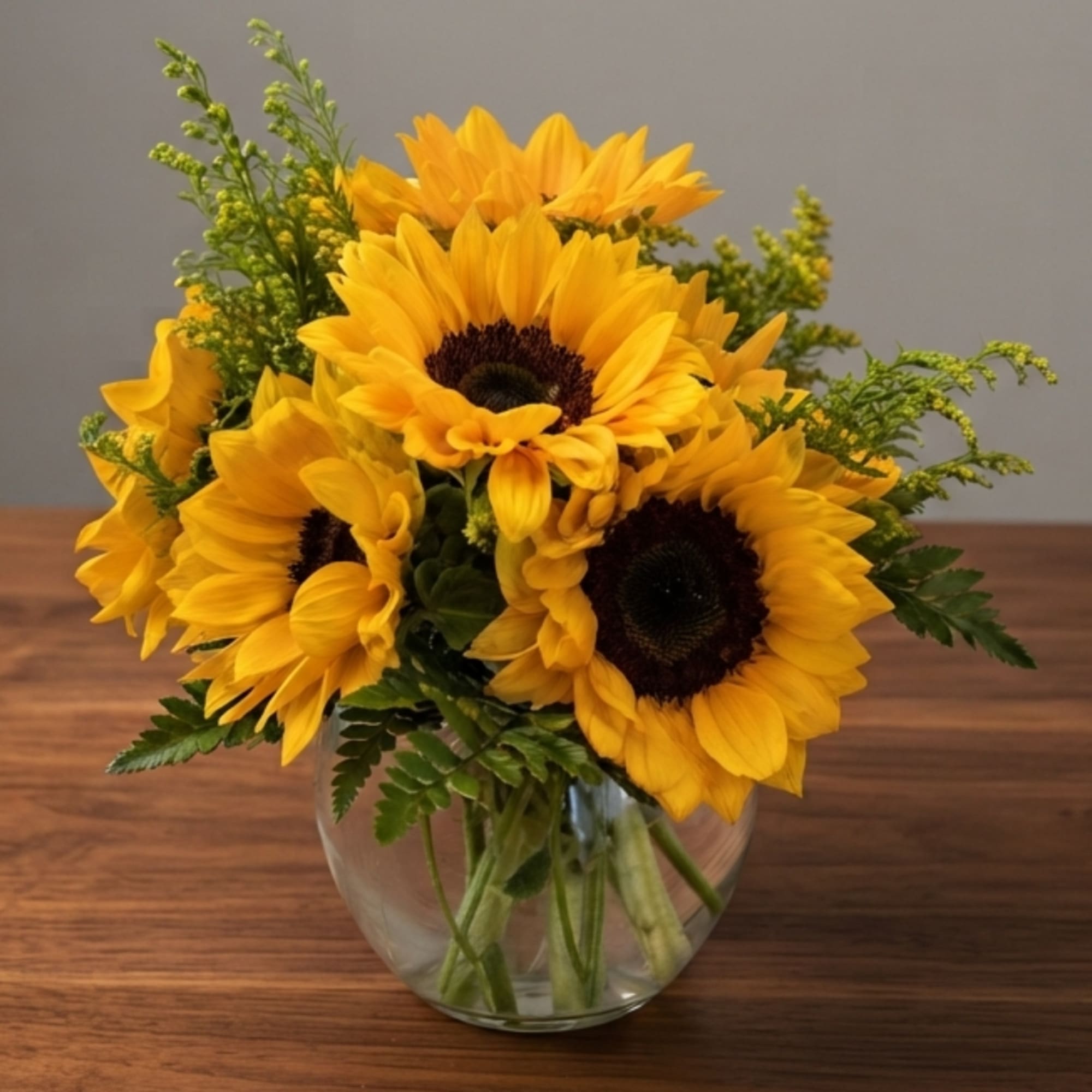 Bouquet of yellow sunflowers in a clear glass vase