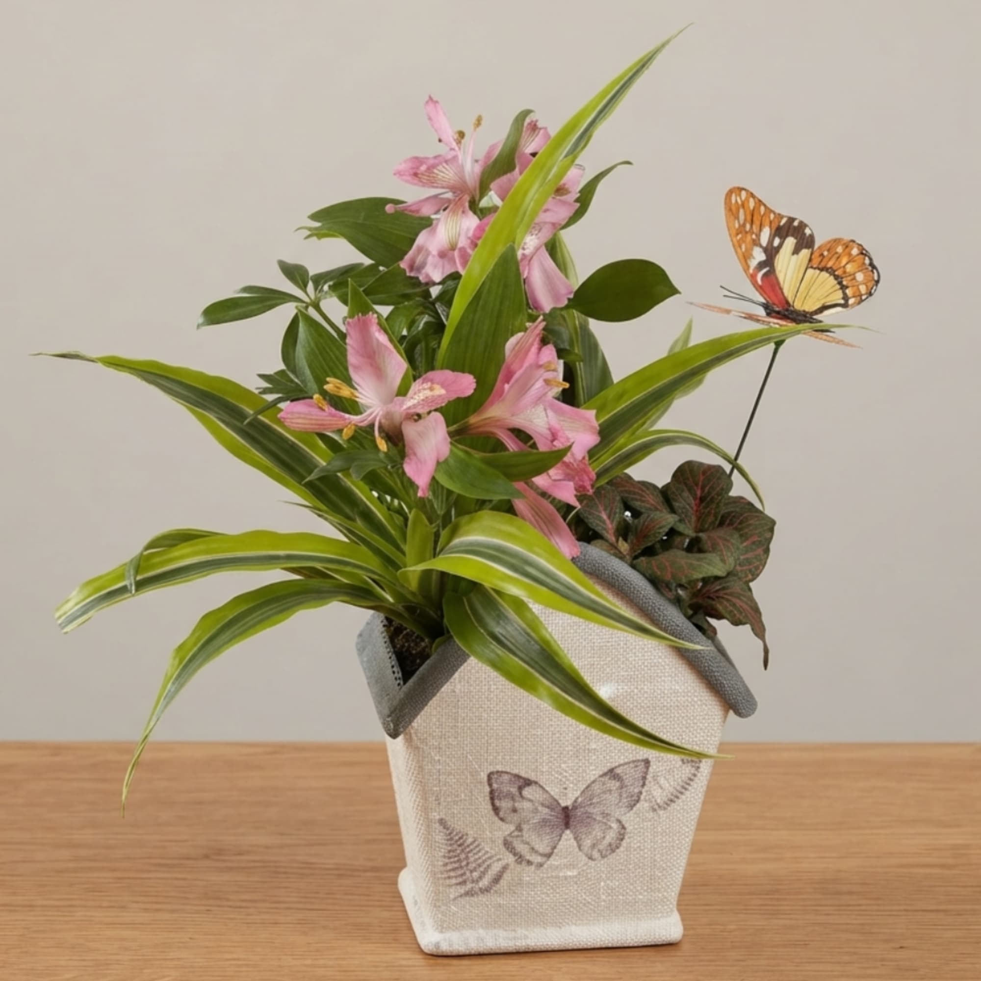 Pink flowers in a butterfly-print fabric planter with green foliage