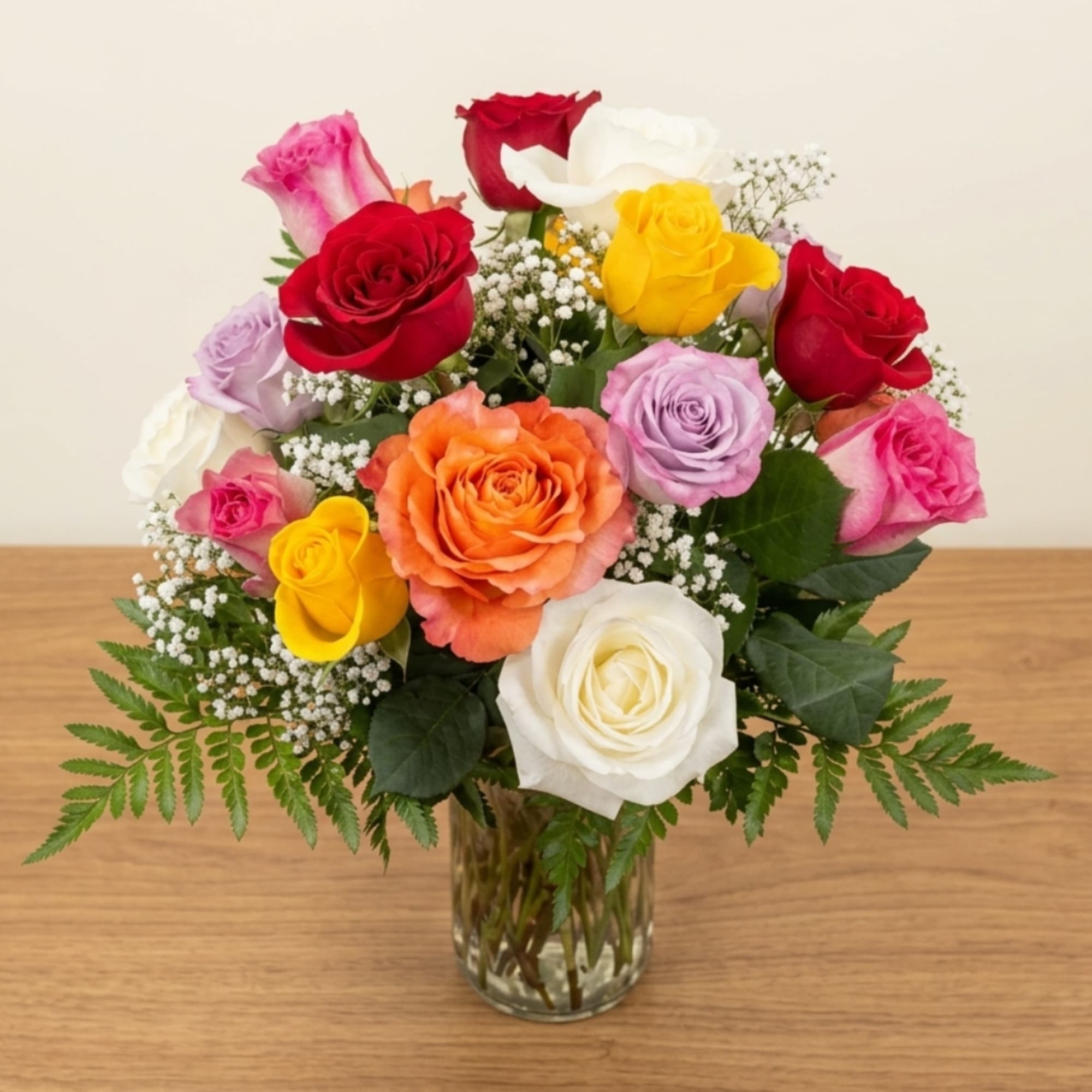 Mixed roses in a glass vase with baby's breath