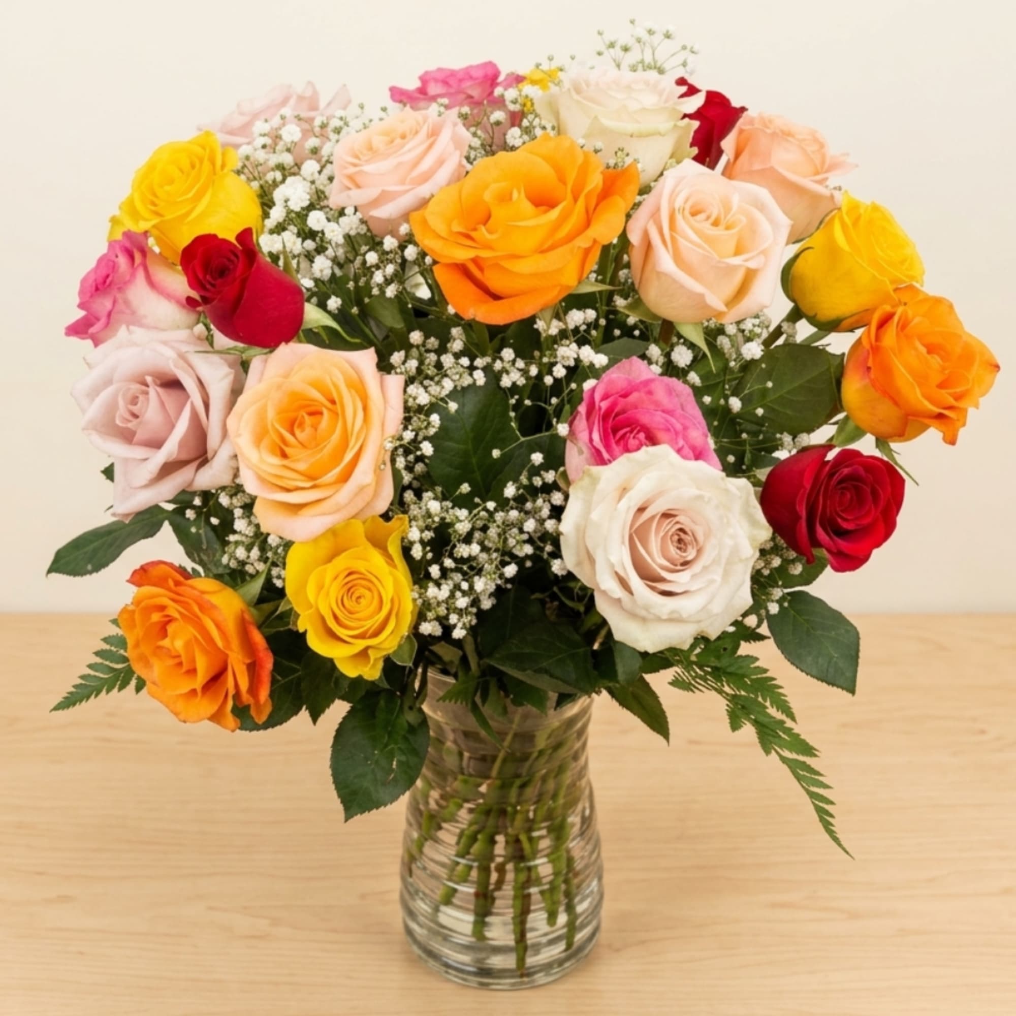 Mixed roses in a clear glass vase with baby's breath