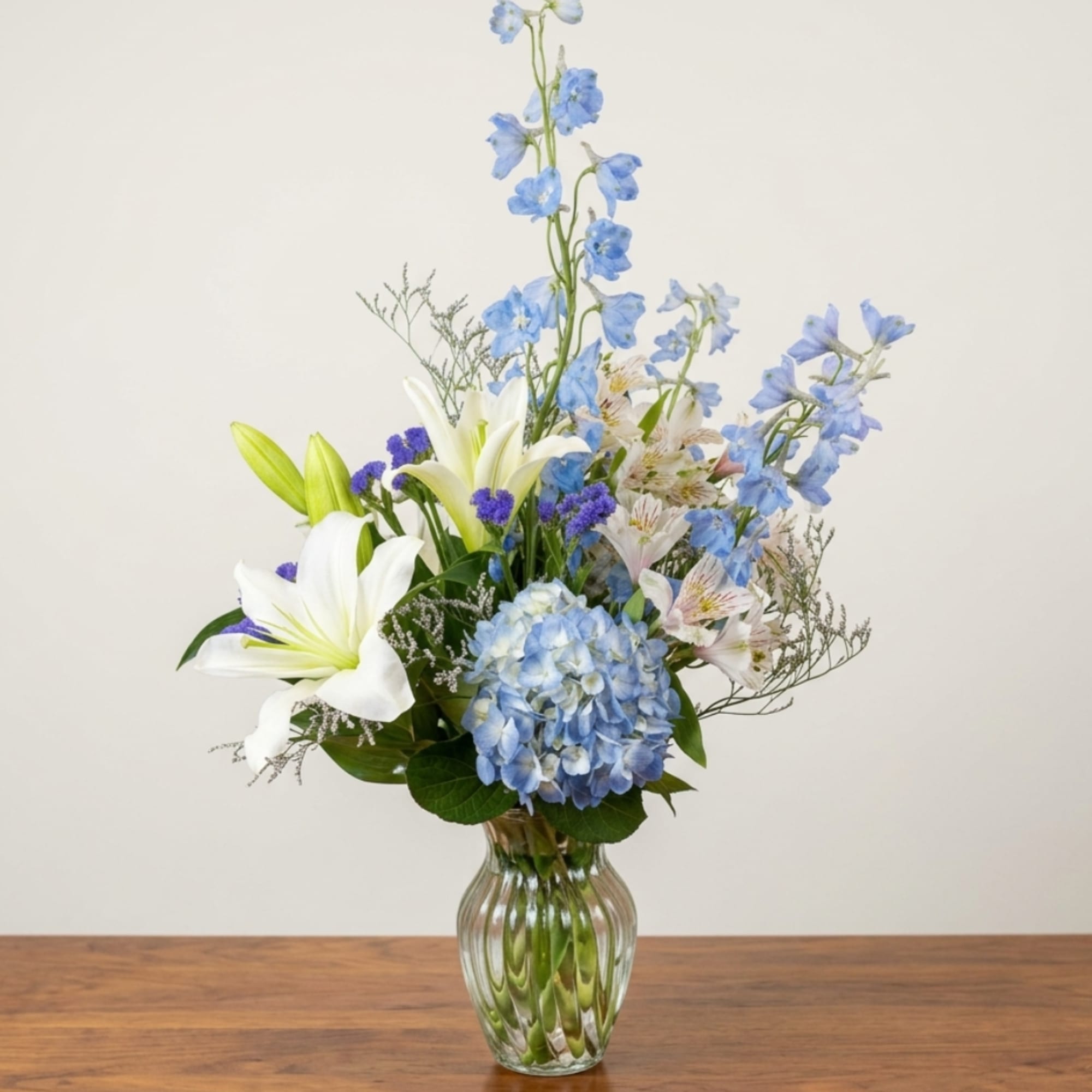 Blue and white floral arrangement in a clear glass vase, photo 4 of 4