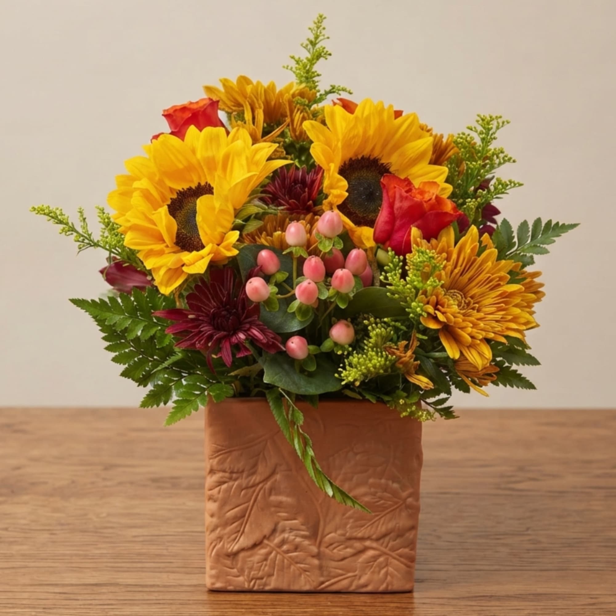 Sunflower and rose arrangement in a square textured vase