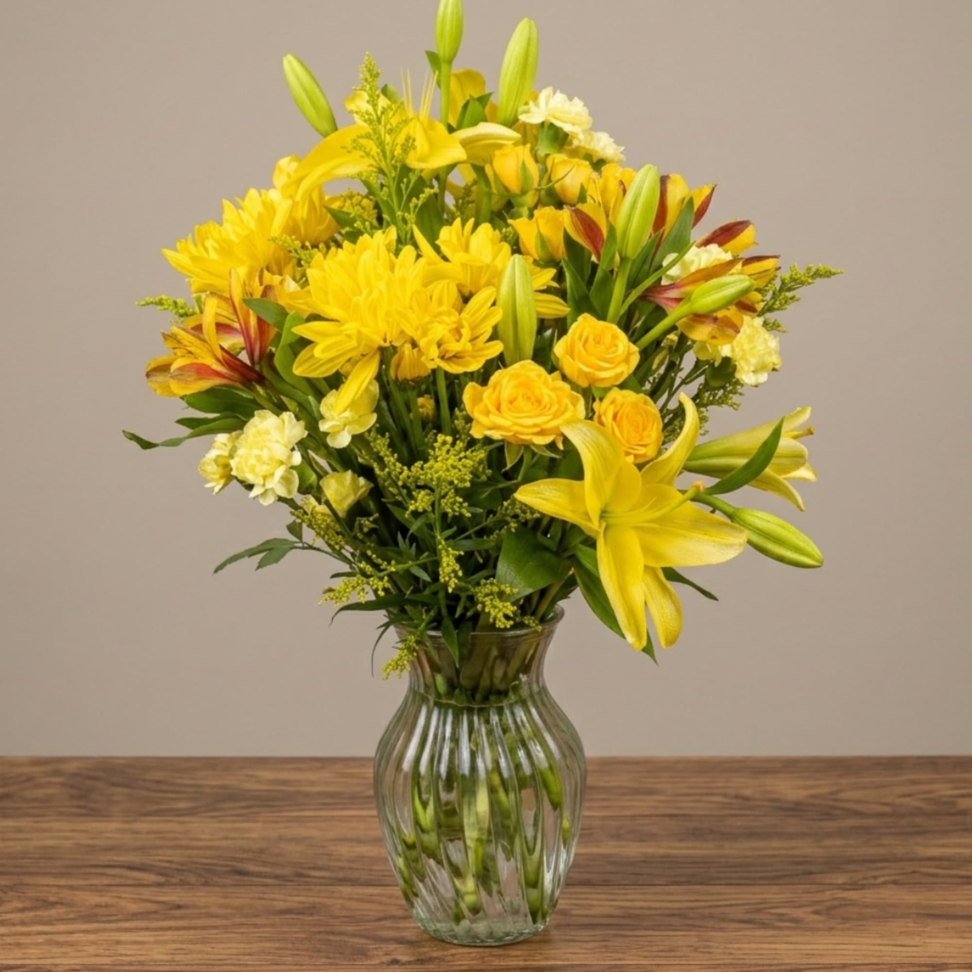 Yellow bouquet with lilies, roses, and chrysanthemums in a glass vase