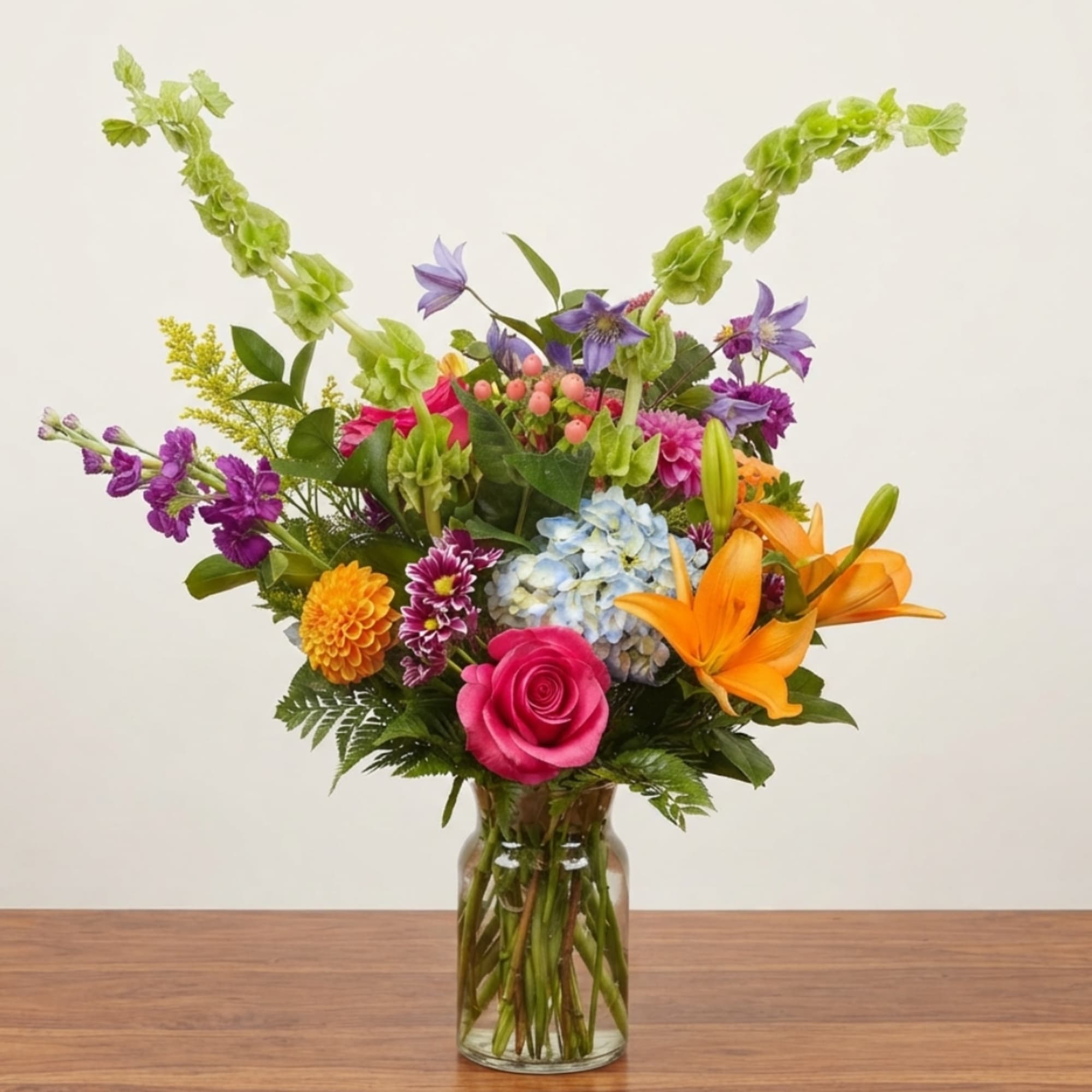 Colorful mixed flower arrangement in a clear glass vase