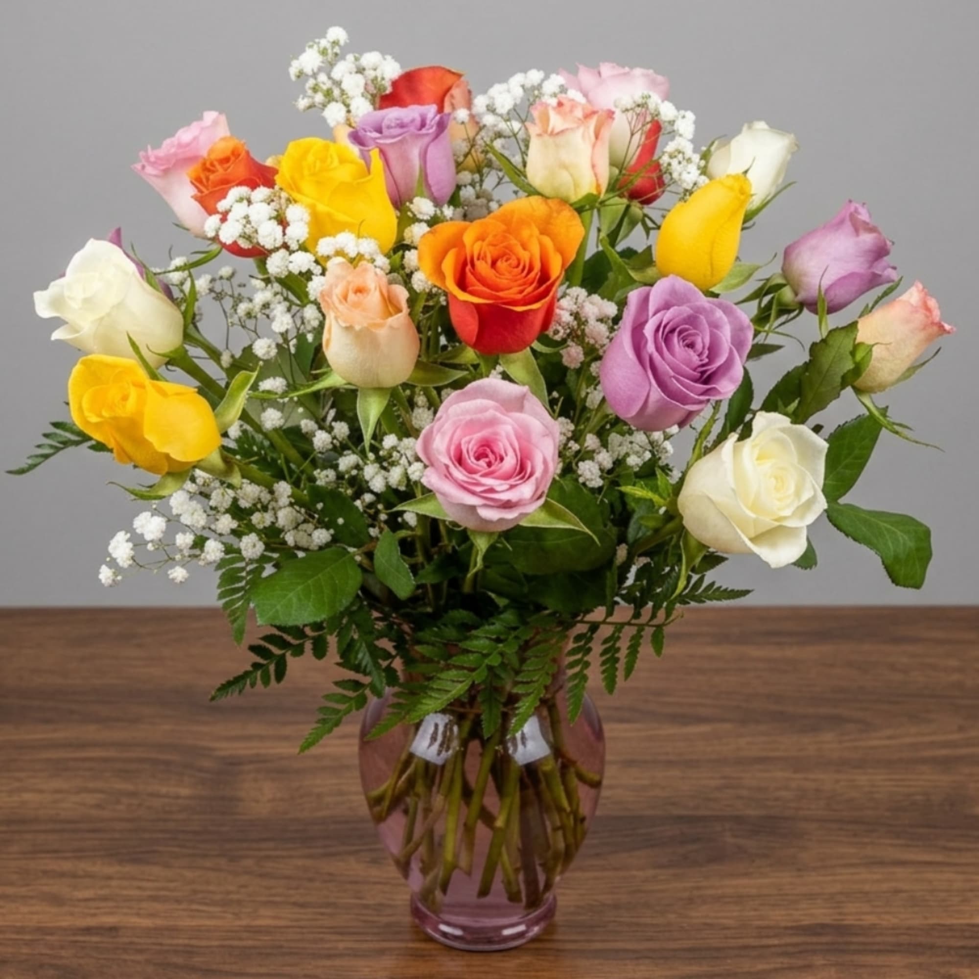 Mixed roses in a glass vase with baby's breath