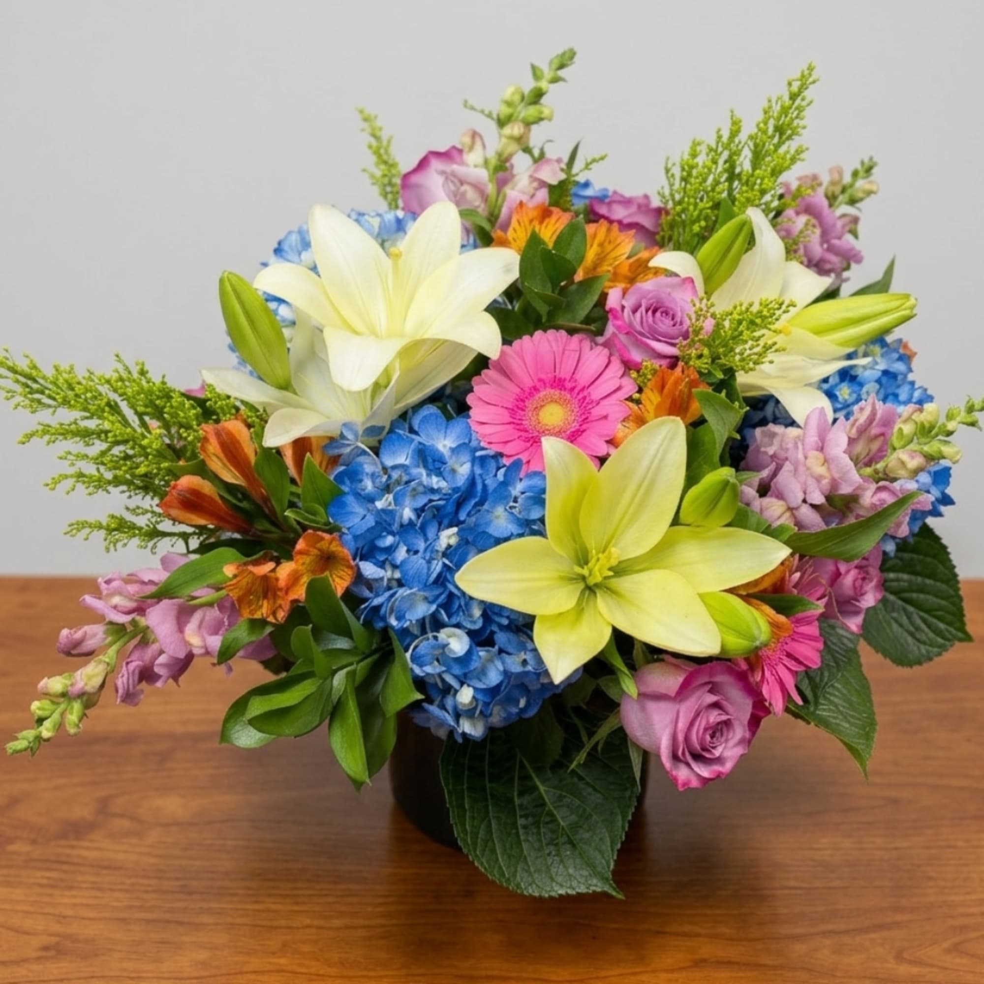 Colorful bouquet with lilies, hydrangeas, roses, and gerbera daisies in a vase