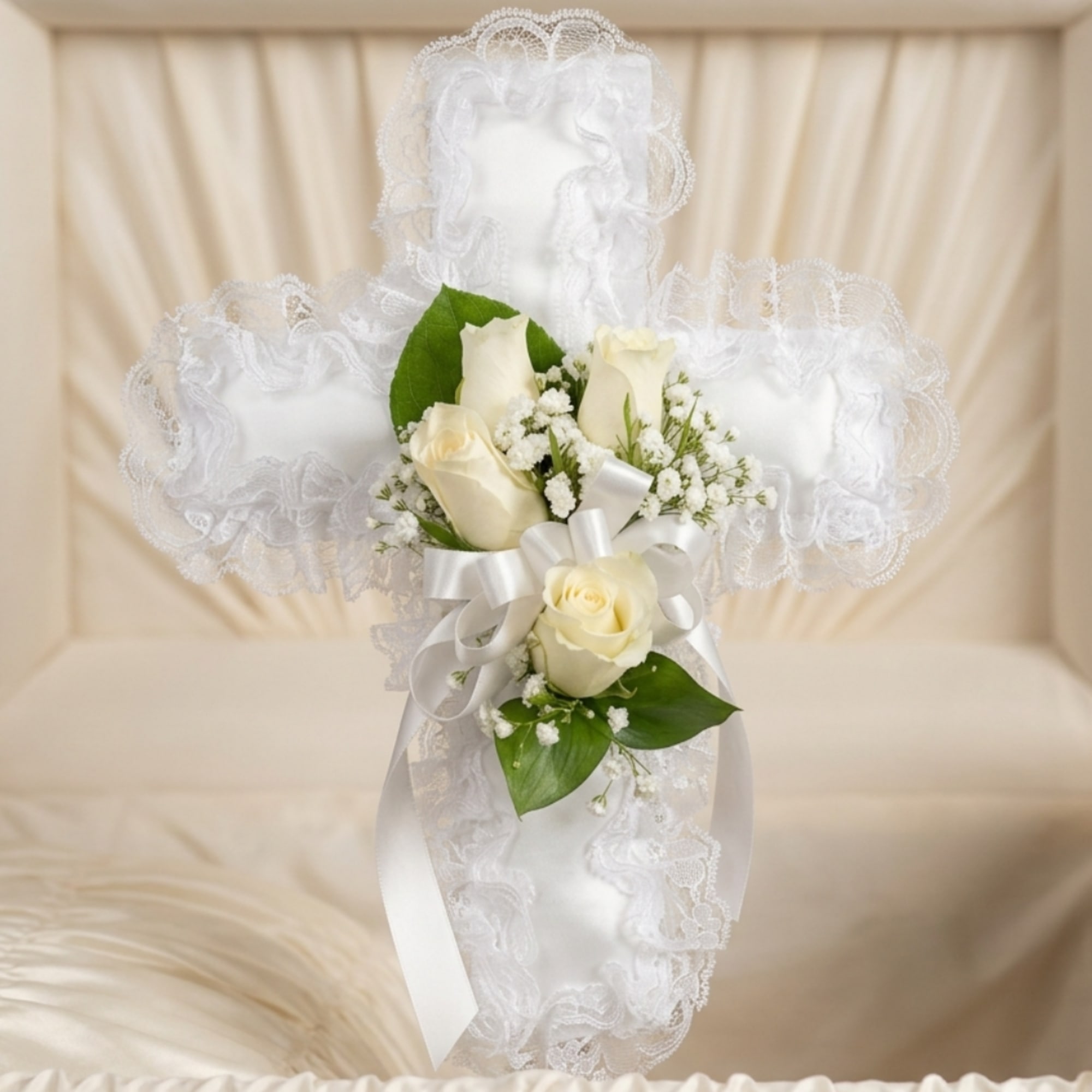 White rose corsage with lace trim and ribbon on a satin cross backdrop