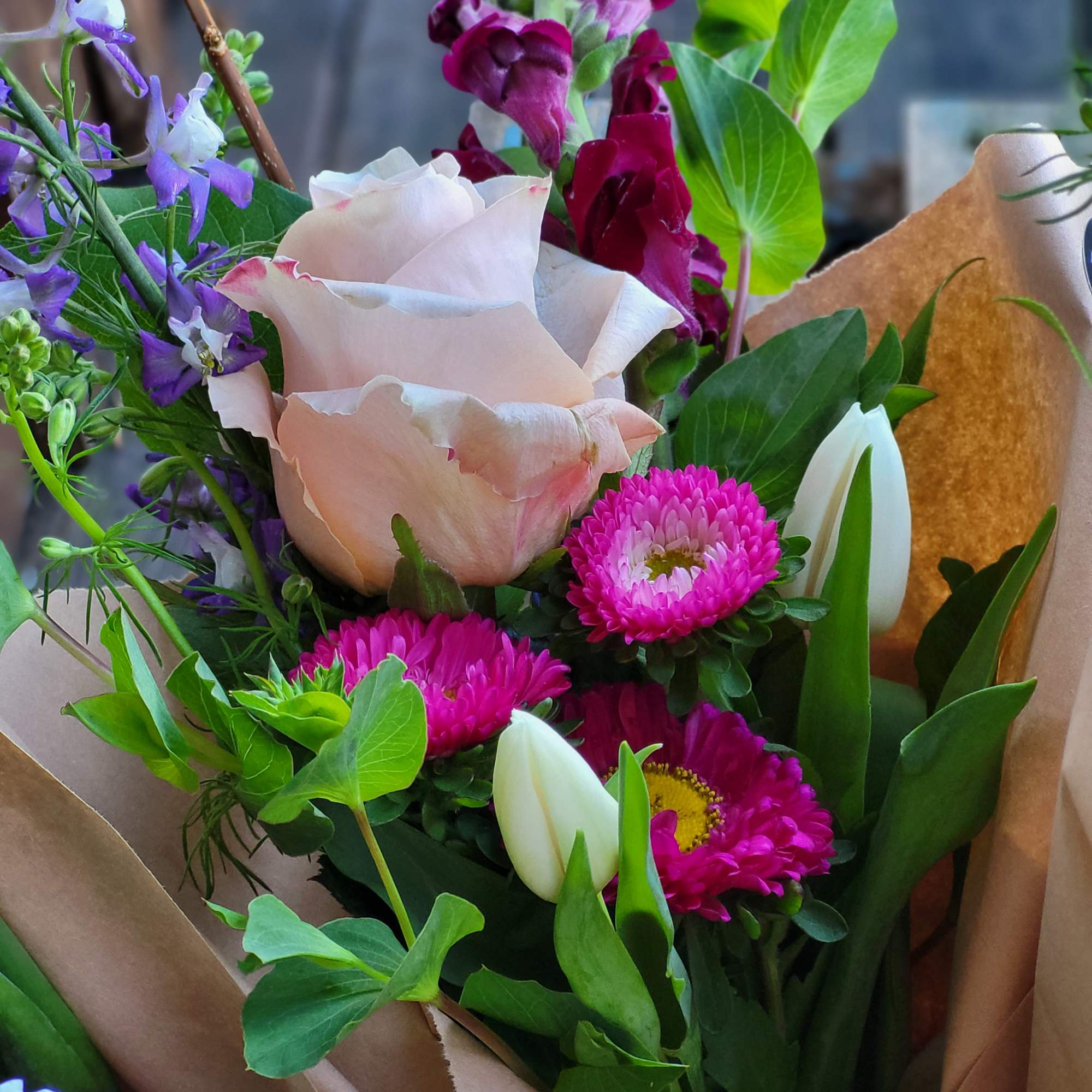 Bouquet of pink roses, magenta daisies, and purple snapdragons