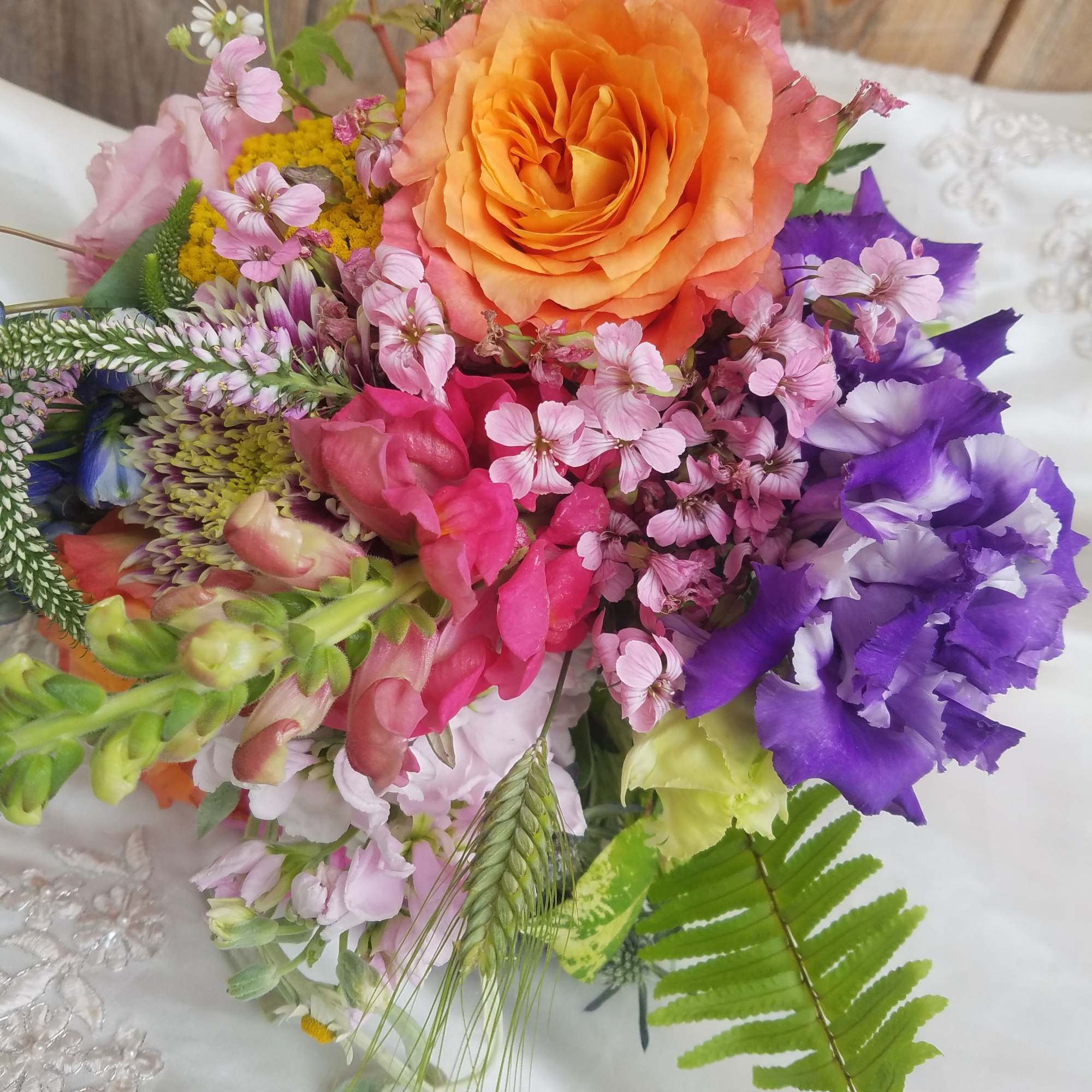 Colorful bouquet with orange rose and purple blooms