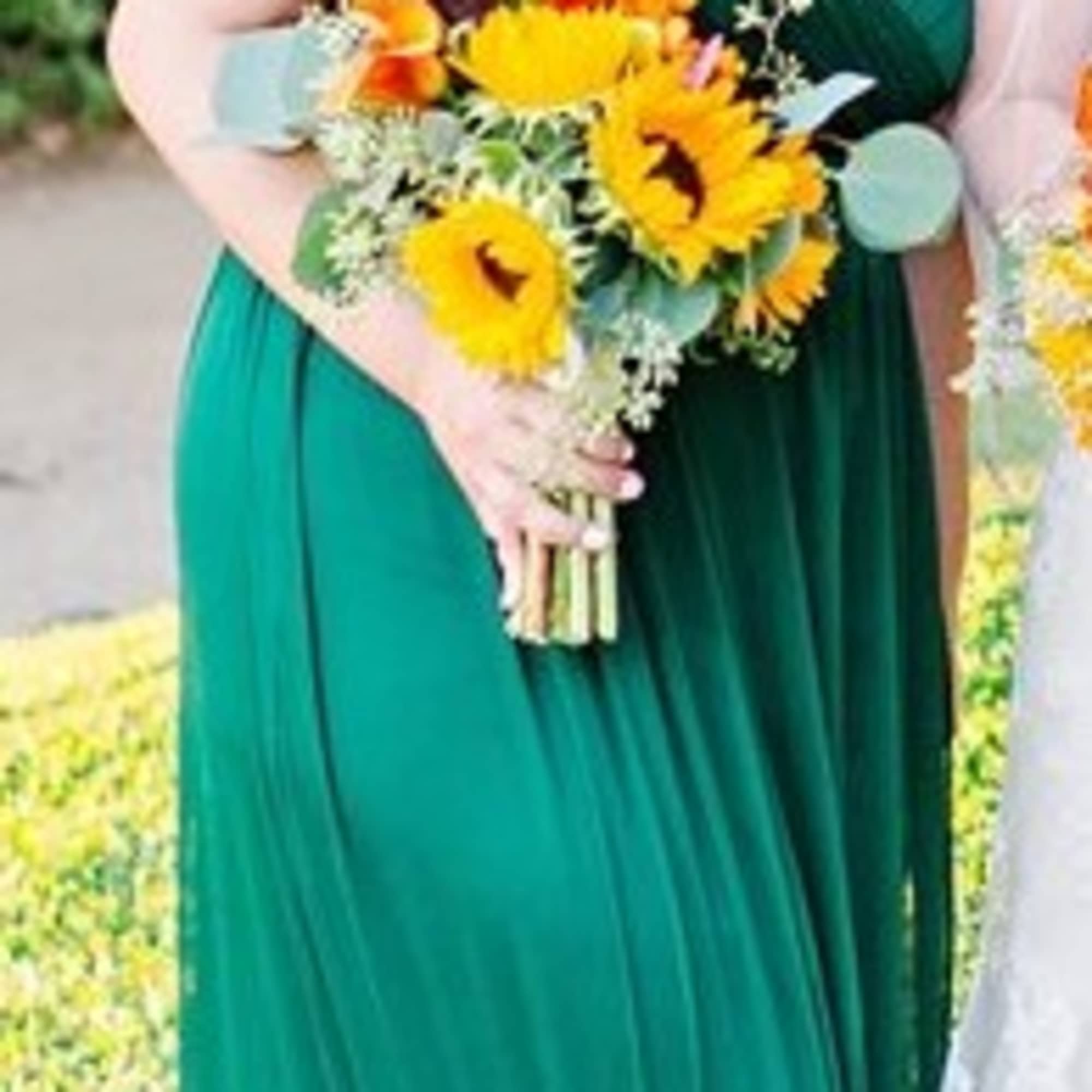 Bridal bouquet of yellow sunflowers with mixed greenery and orange accents