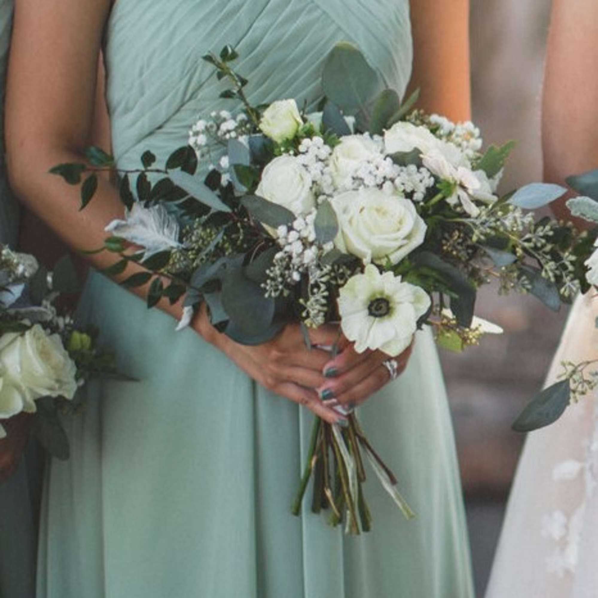 Bridesmaid holding a white and green bouquet