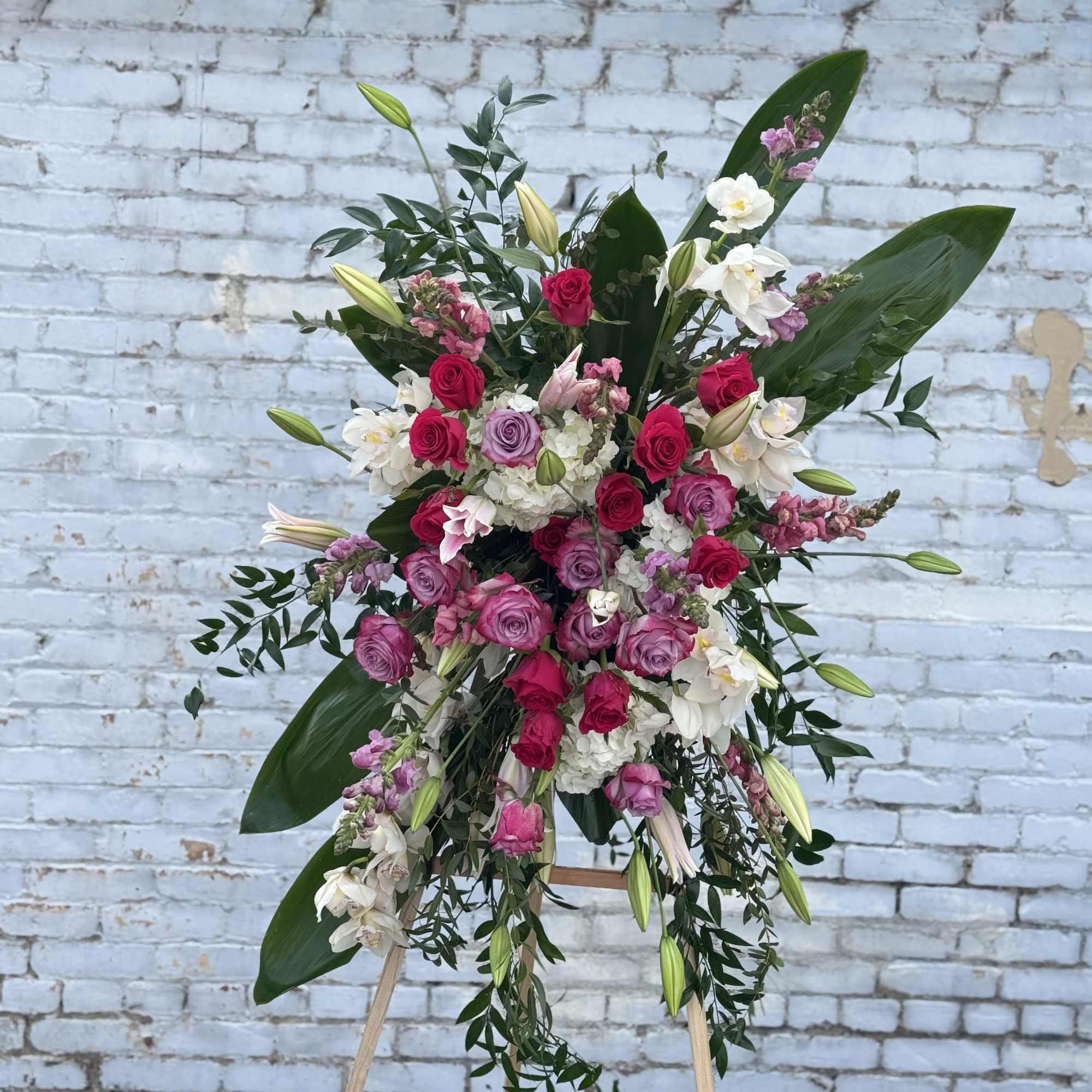 Large standing floral spray with pink and white roses on an easel