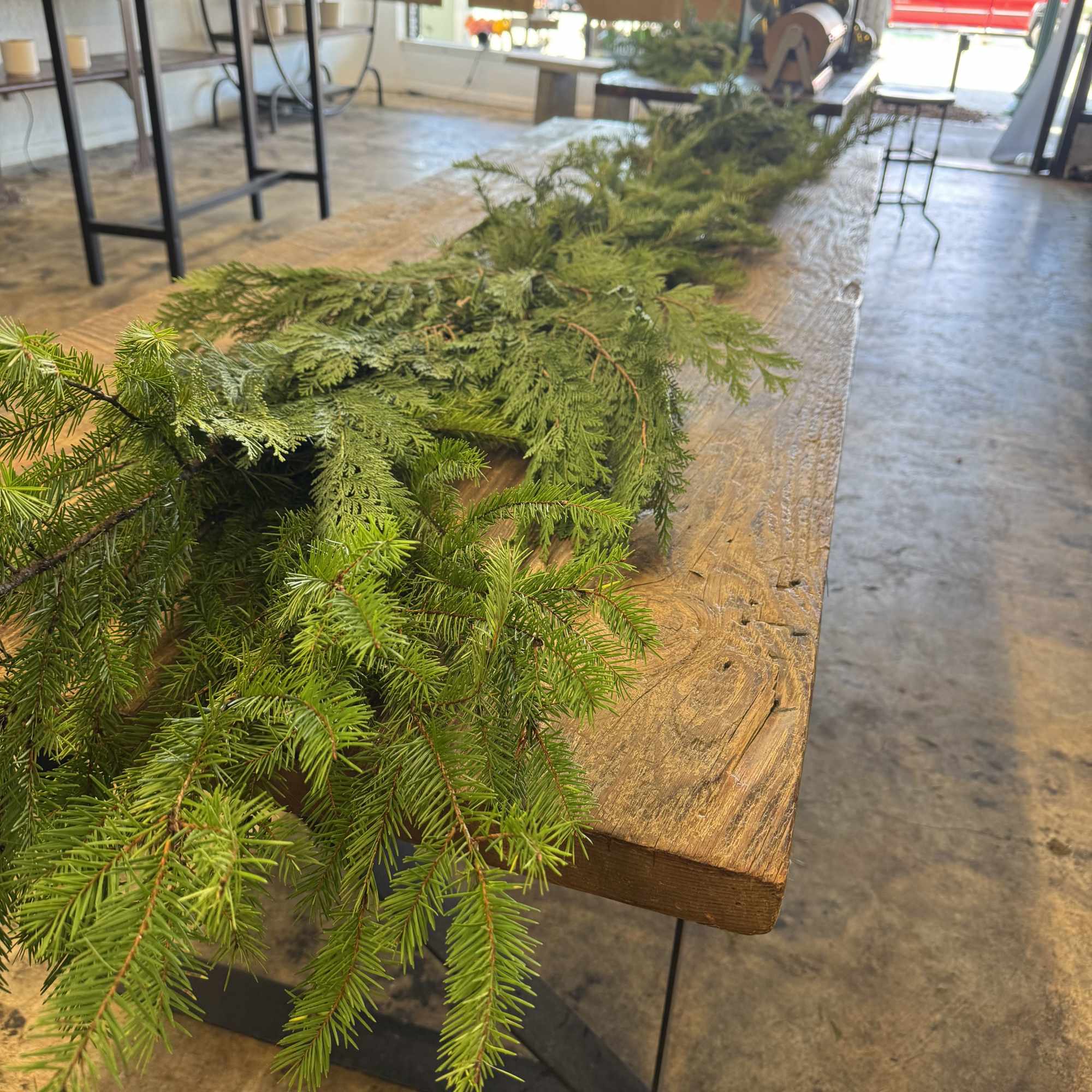 Long evergreen garland laid across a wooden table