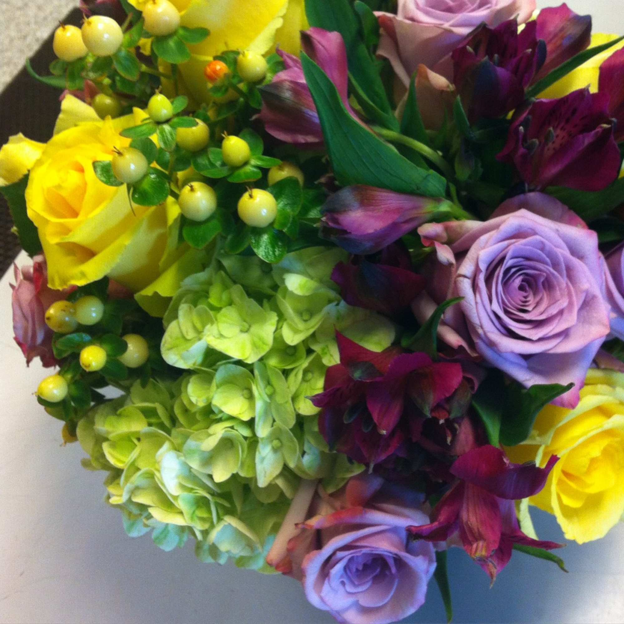 Bouquet of yellow and lavender roses with green hydrangeas and purple flowers