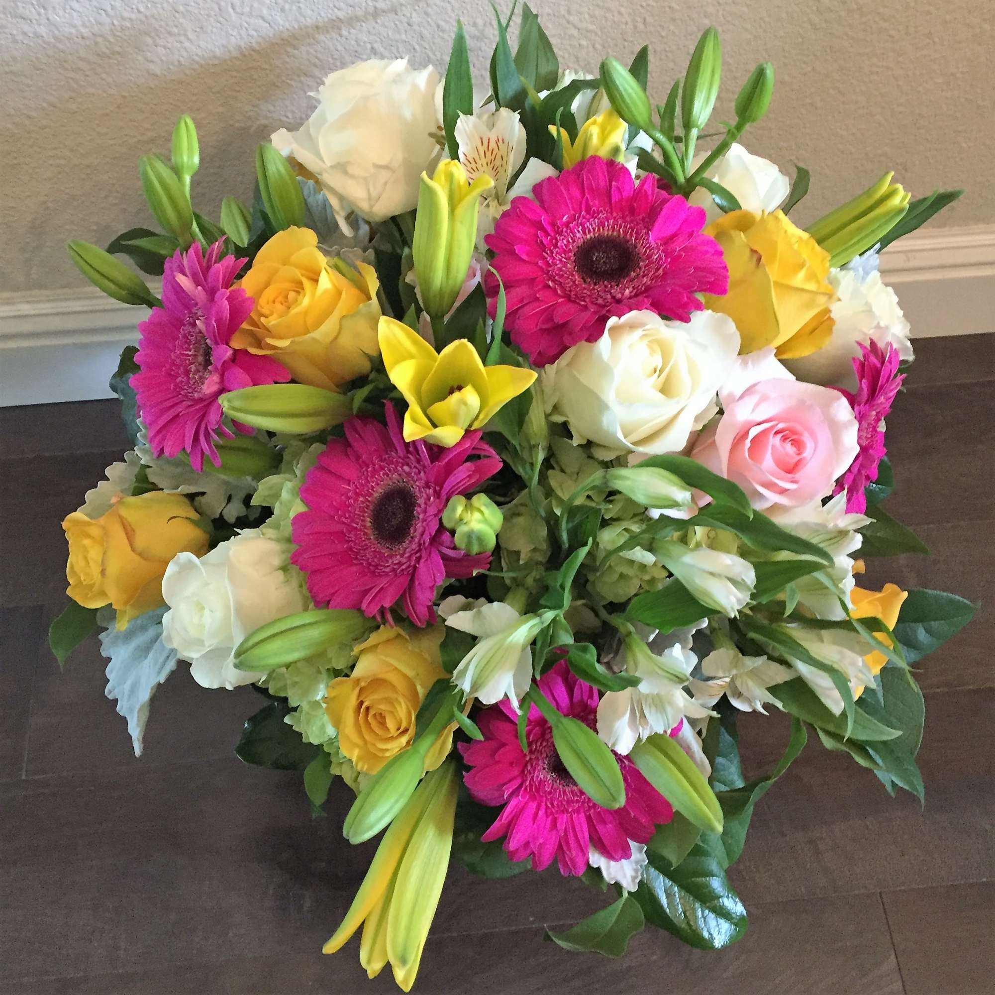 Bouquet of pink gerbera daisies, yellow and white roses, and lilies