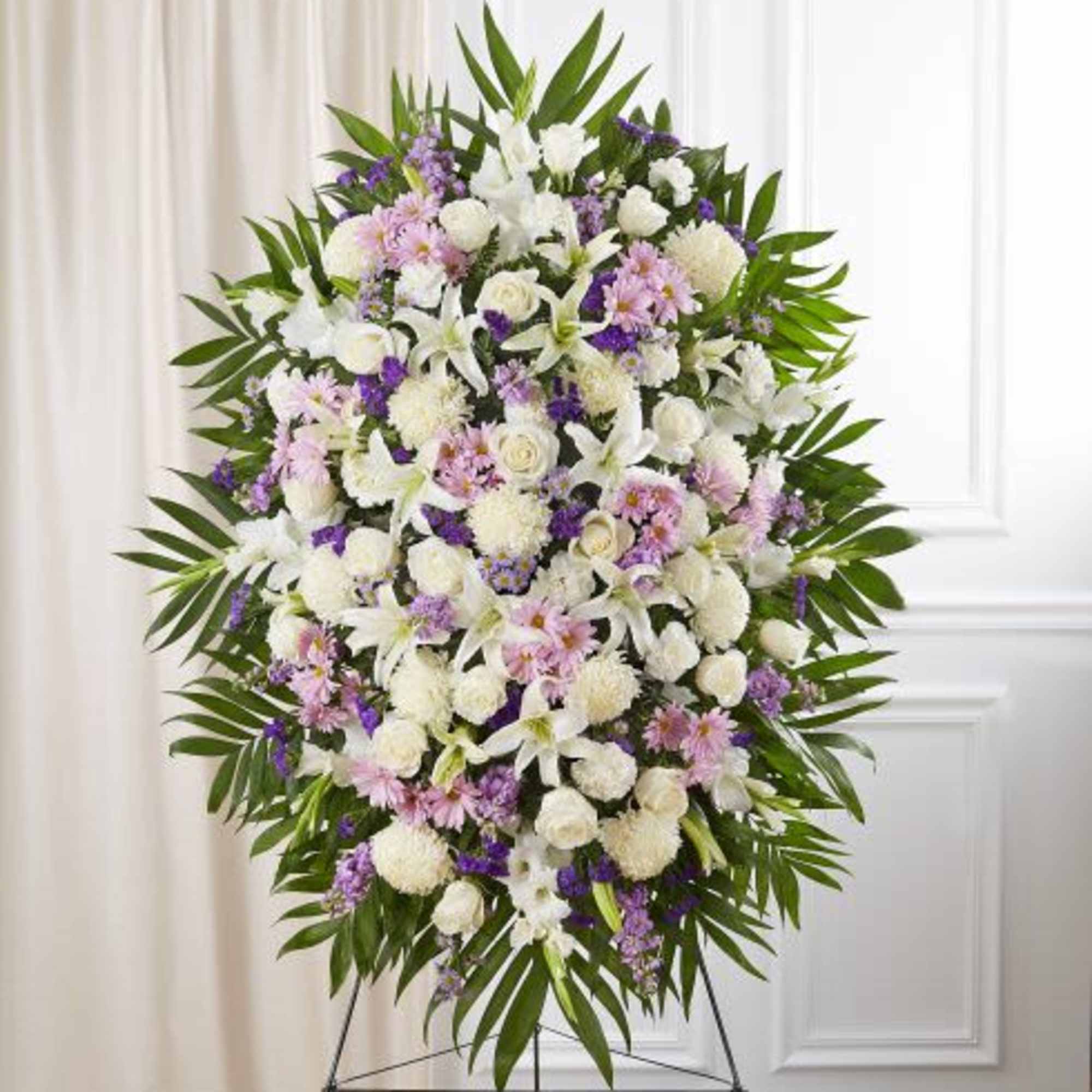 Tall standing spray of white, pink, and purple flowers on a metal easel