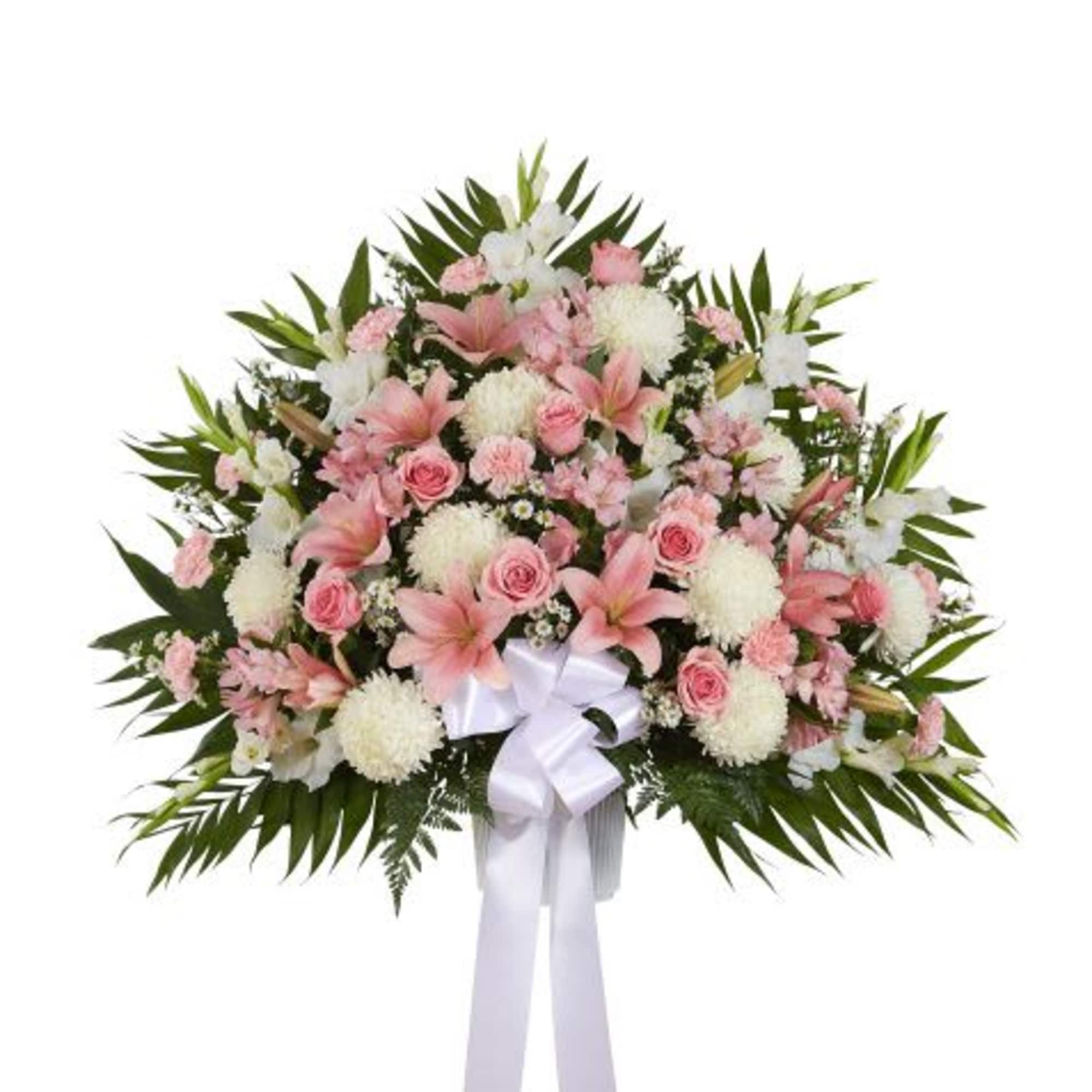Large pink and white standing spray with roses, lilies, and a white ribbon bow.