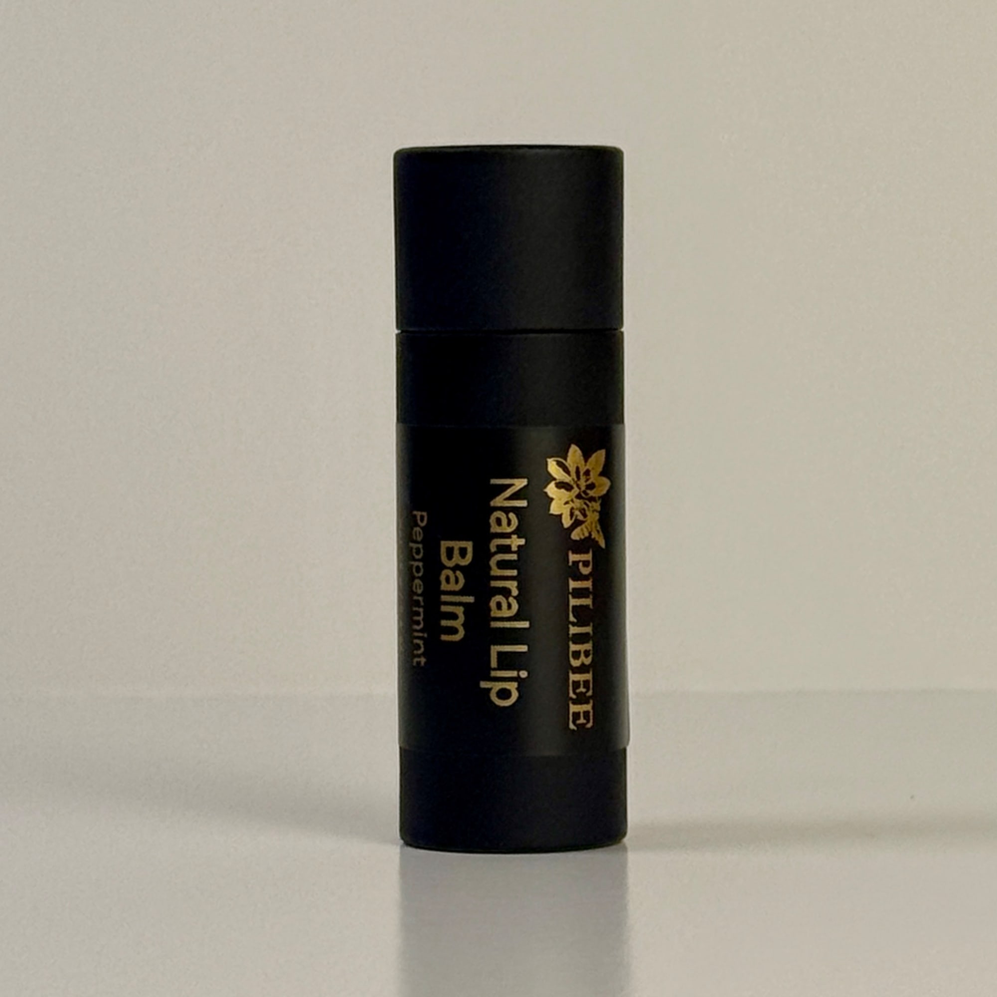 Black lip balm tube labeled Natural Lip Balm Peppermint