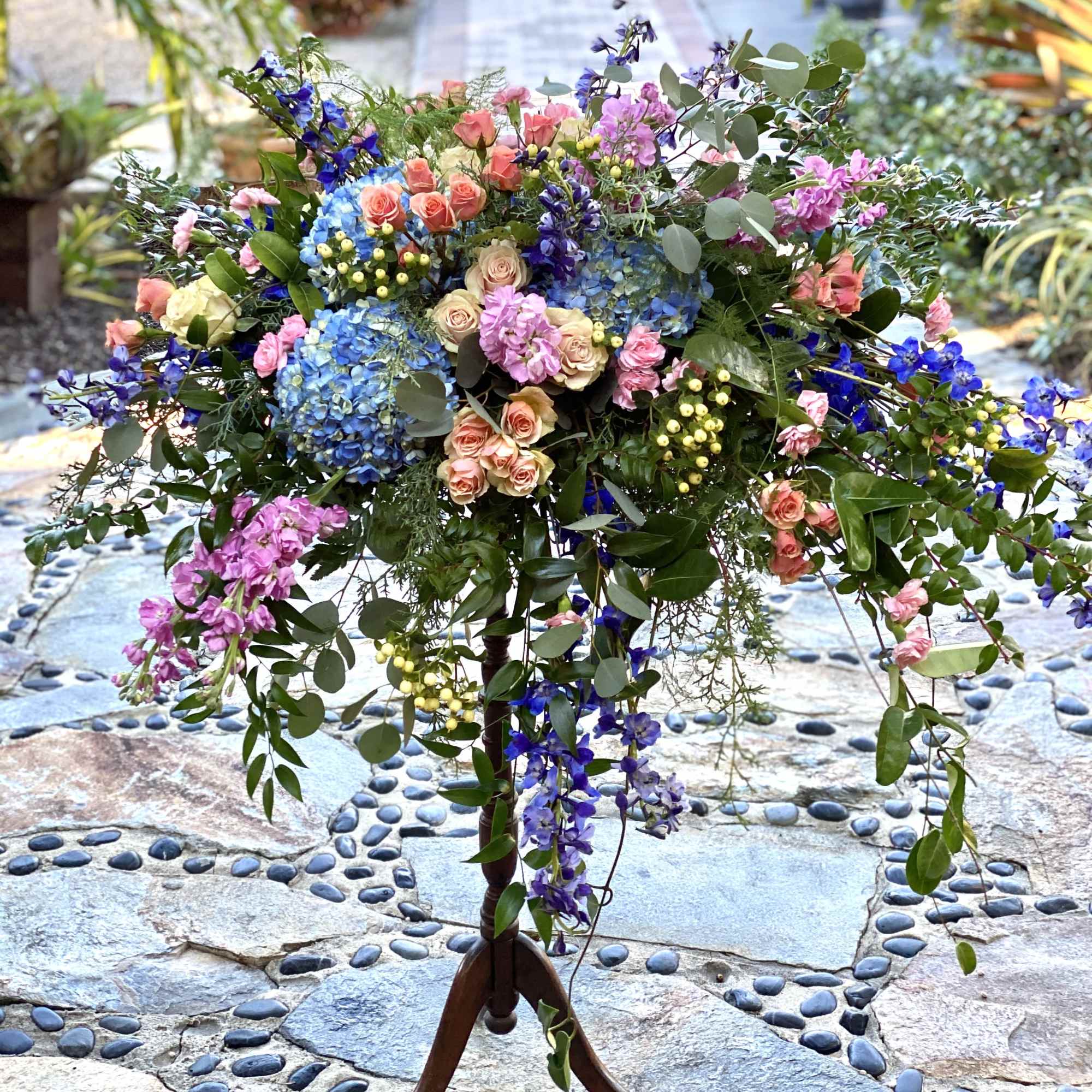 Large mixed floral arrangement on a wooden stand