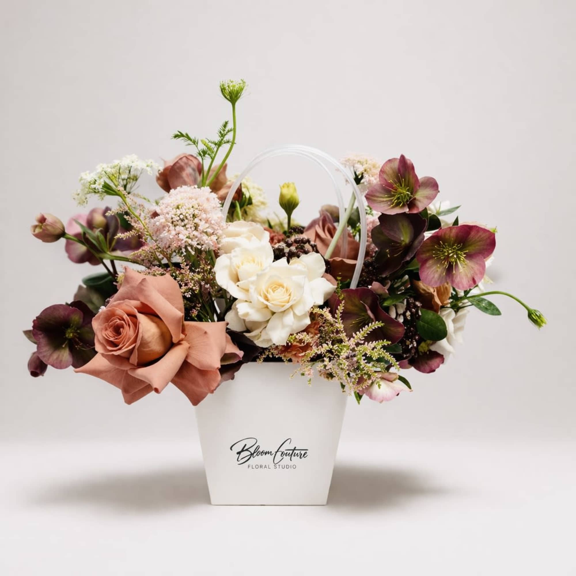 This arrangement blends soft romance with rich, moody tones. Cream and dusty-pink