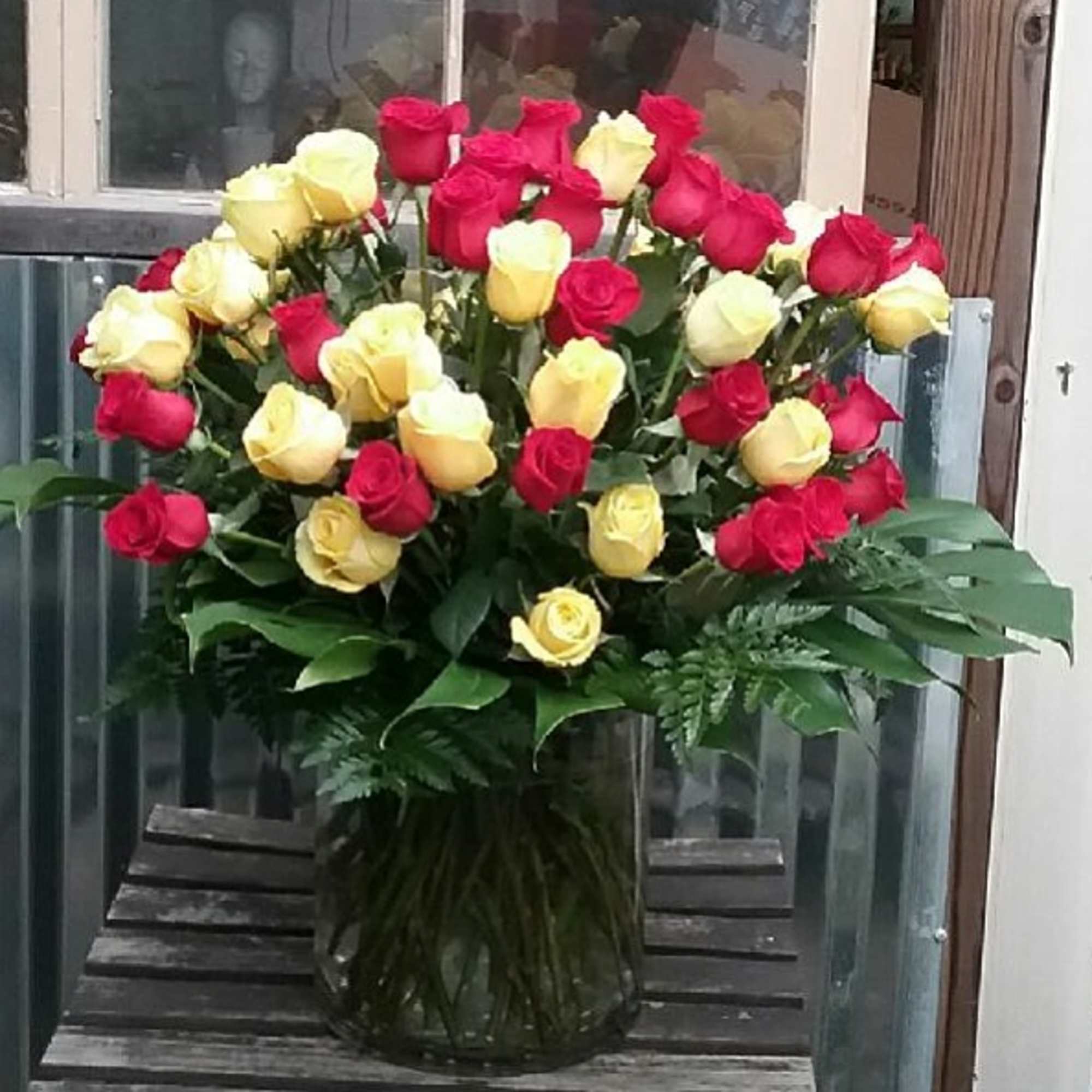 Bouquet of red and yellow roses in a glass vase
