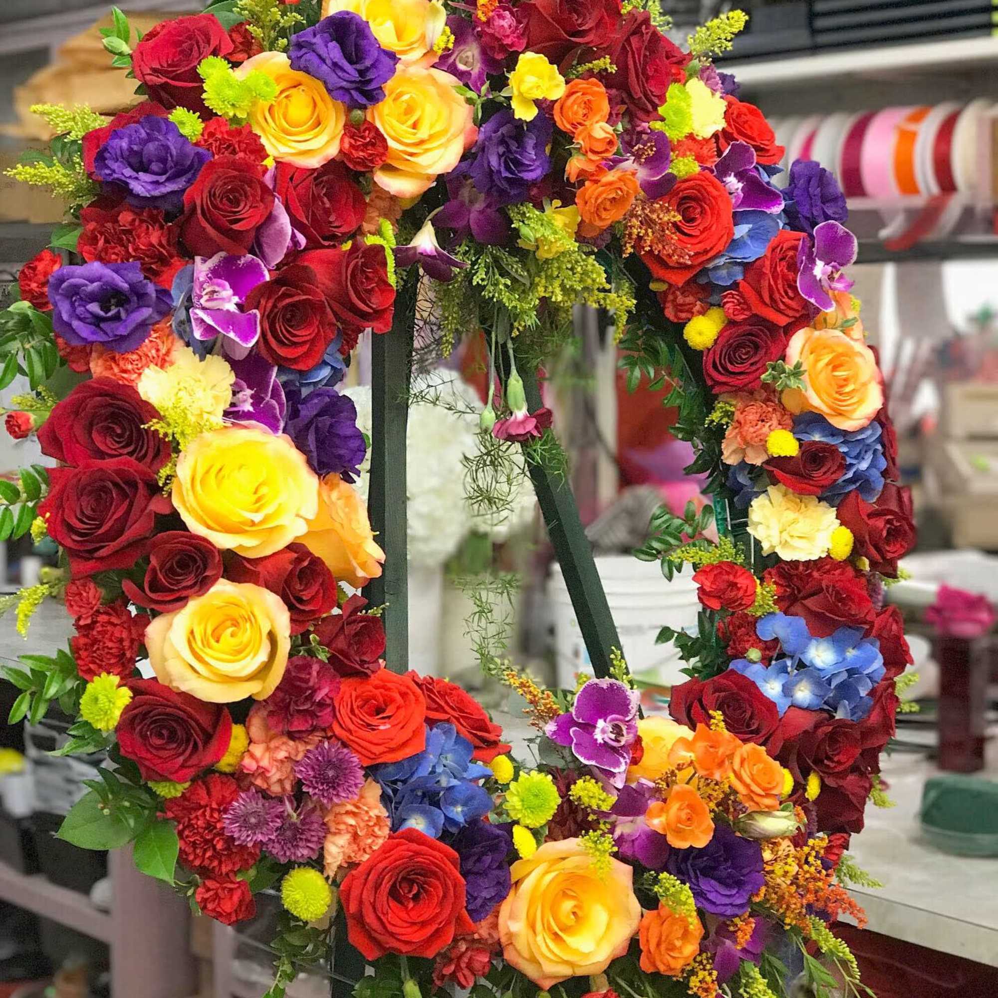 Large circular floral wreath with multicolored roses and orchids