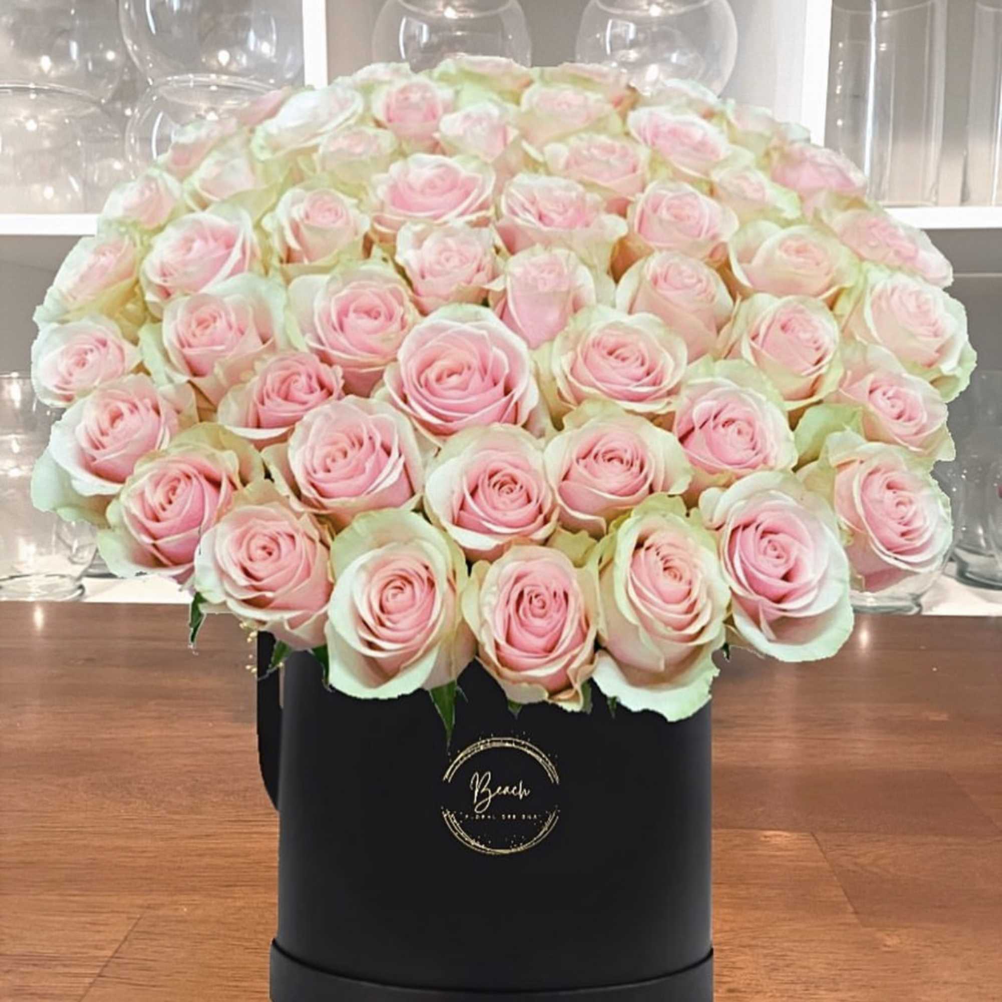 Large bouquet of pale pink roses in a black hat box