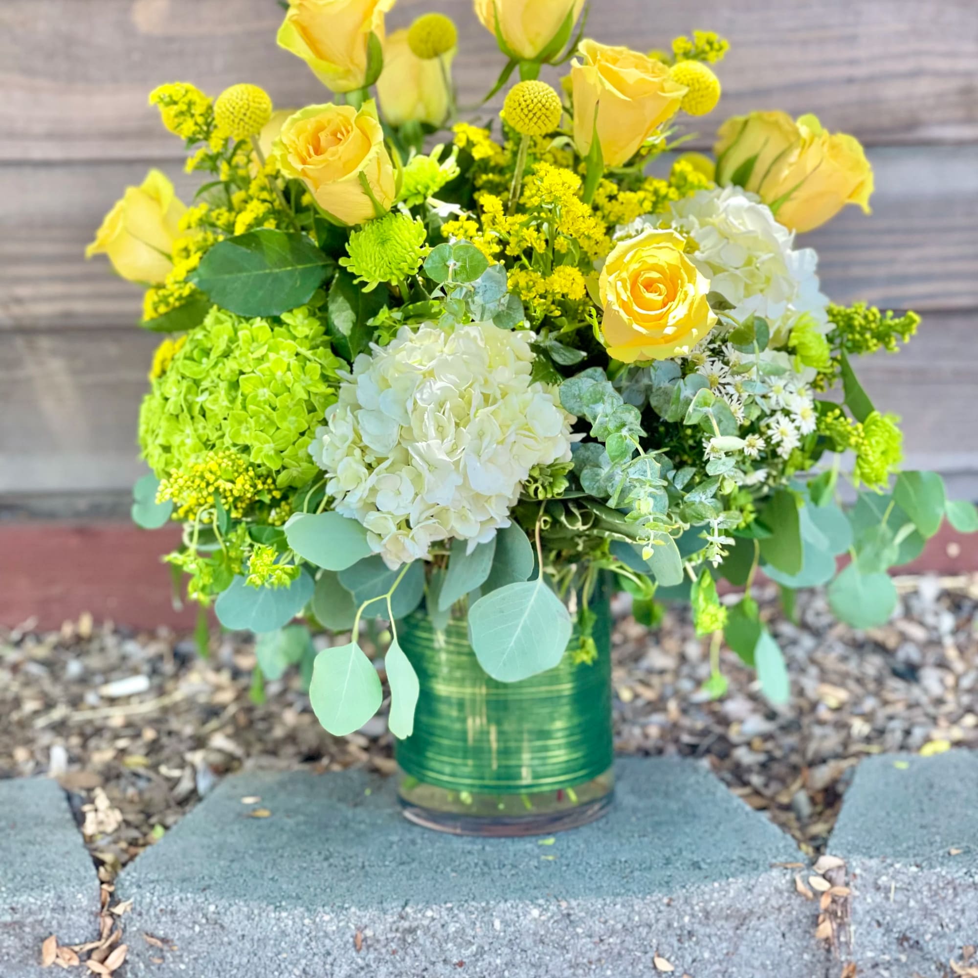 Yellow roses and white hydrangeas in a glass vase