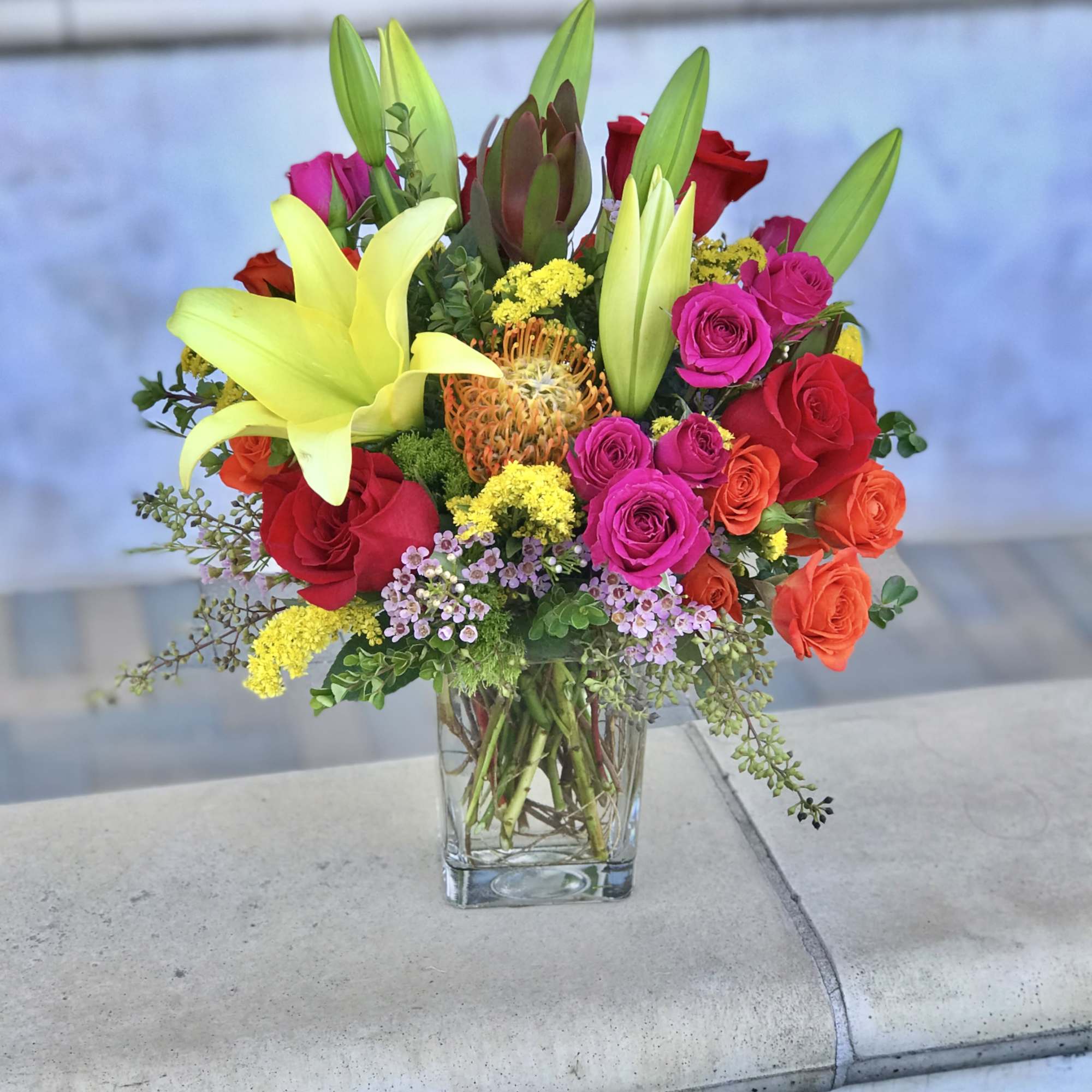 Mixed bouquet of lilies and roses in a clear glass vase, photo 2 of 2